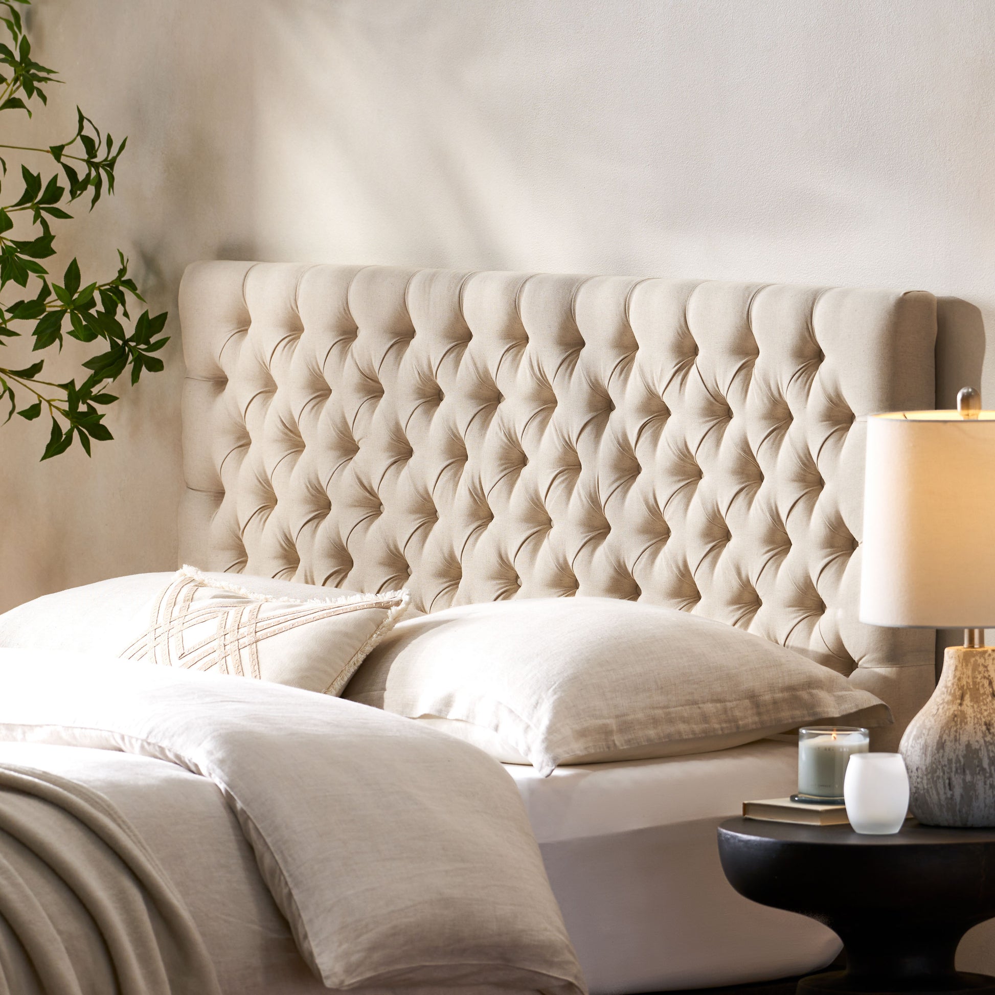 Tufted beige linen headboard with diamond button tufting and rolled edges