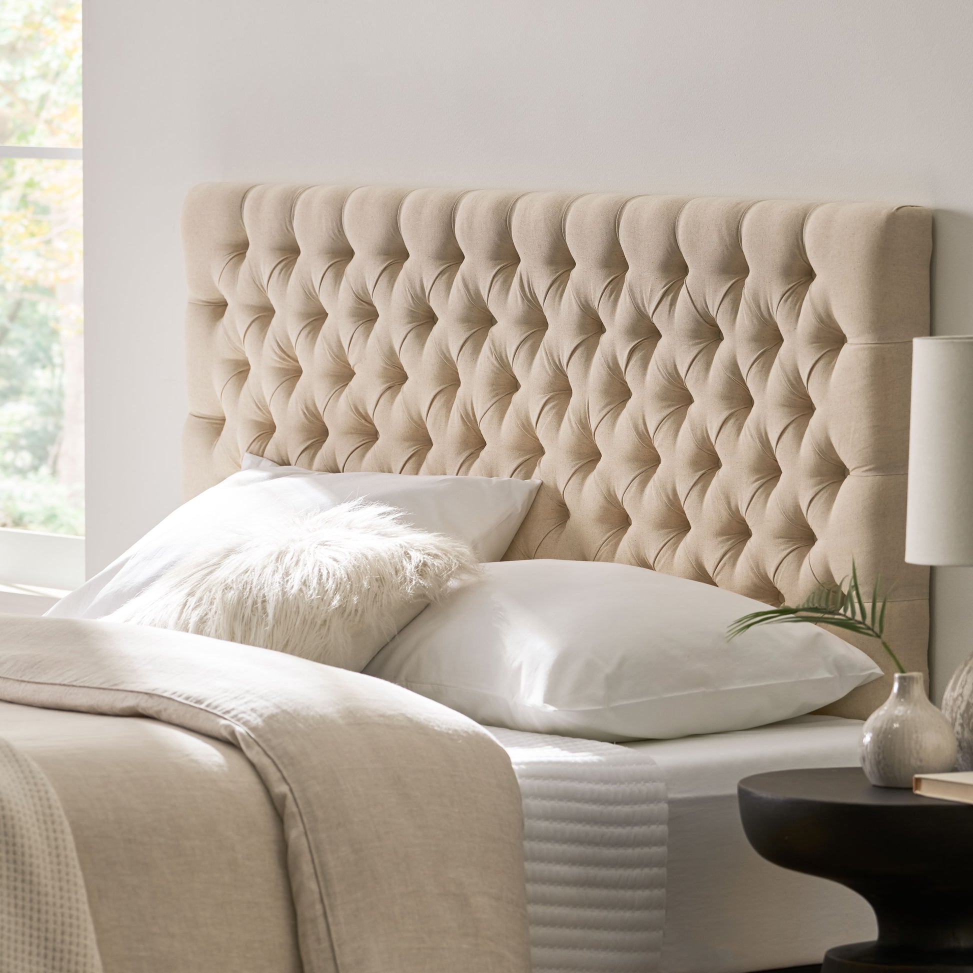 Tufted beige fabric headboard with diamond button tufting
