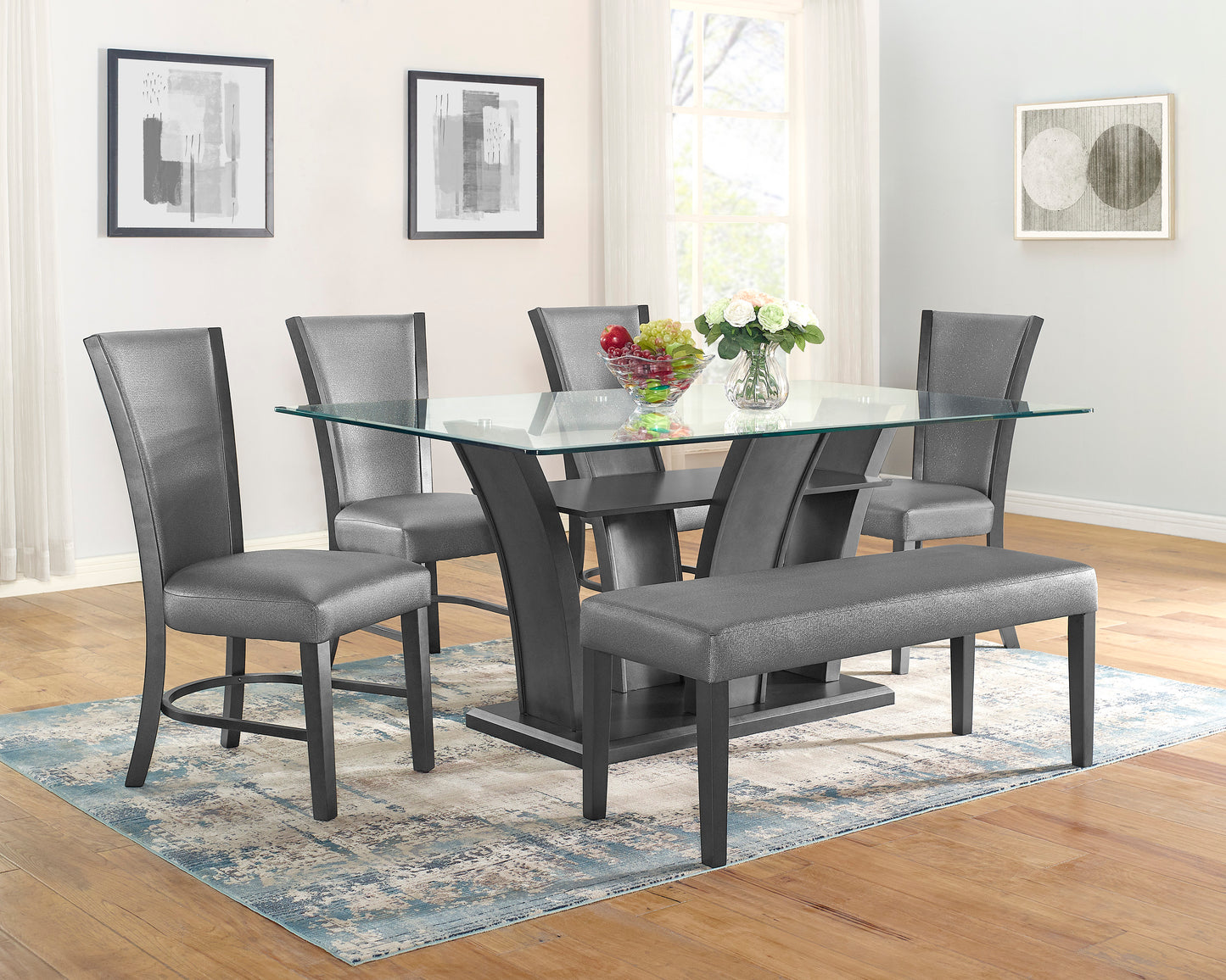 Glass top dining table with gray upholstered chairs and bench