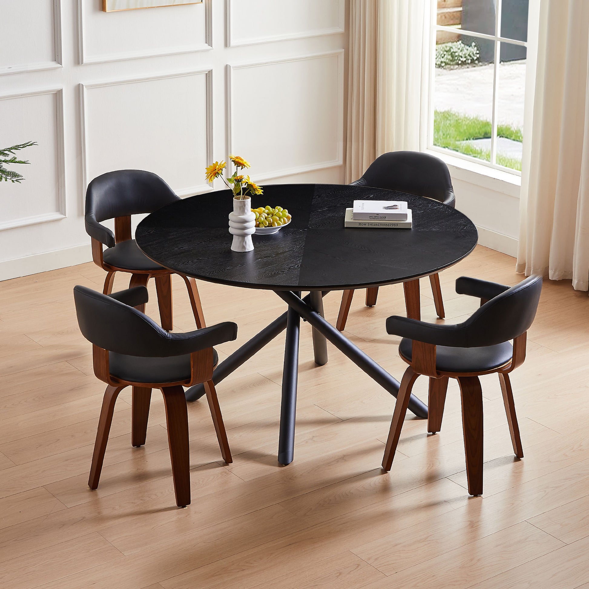 Black round dining table with curved wood chairs