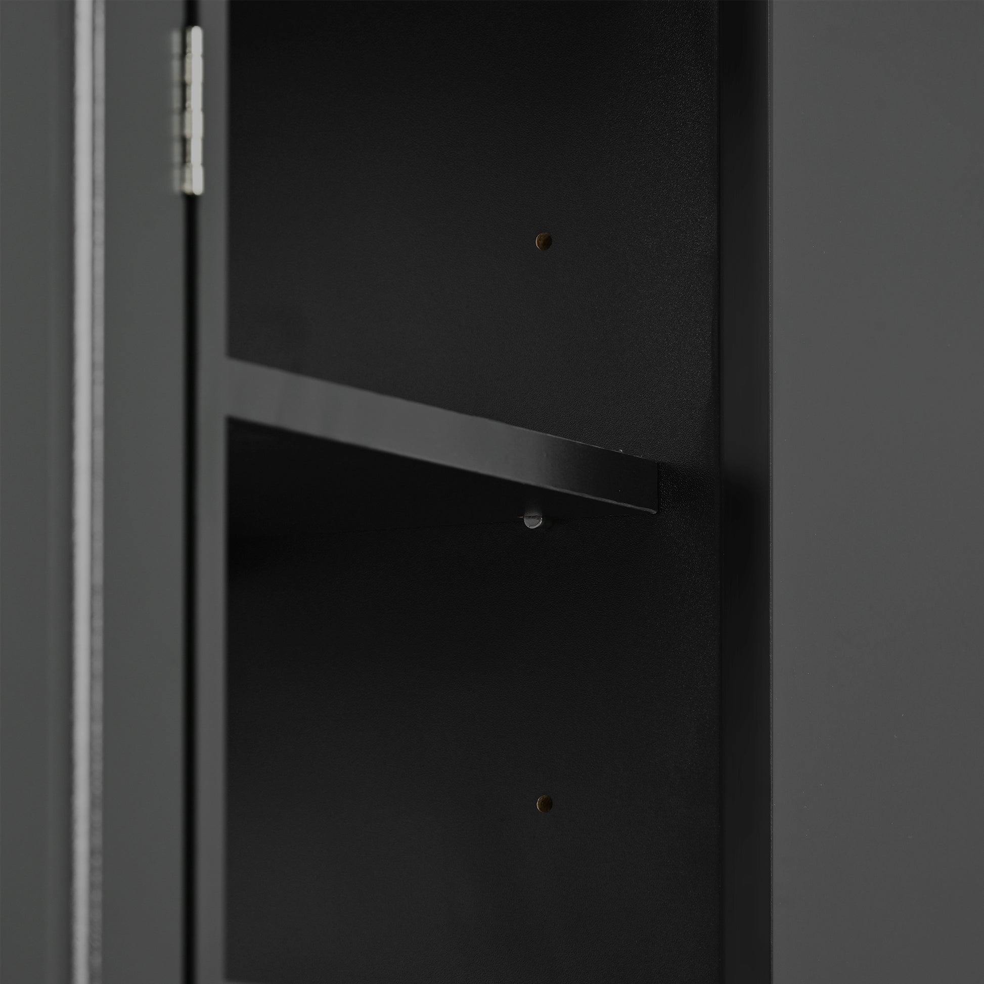 Closeup of a dark gray metal cabinet interior showing a fixed shelf and mounting screws