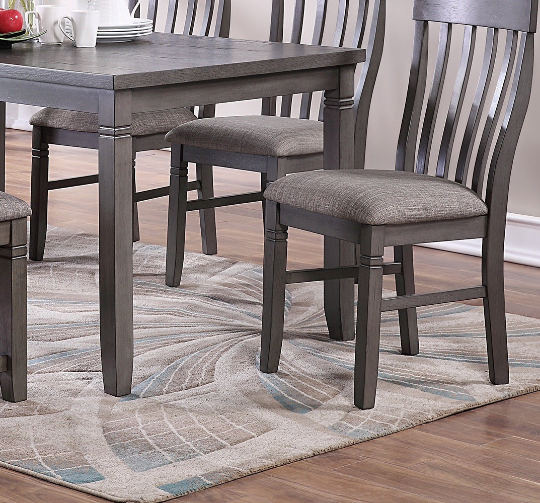 Gray wooden dining chairs with upholstered seats on a patterned rug