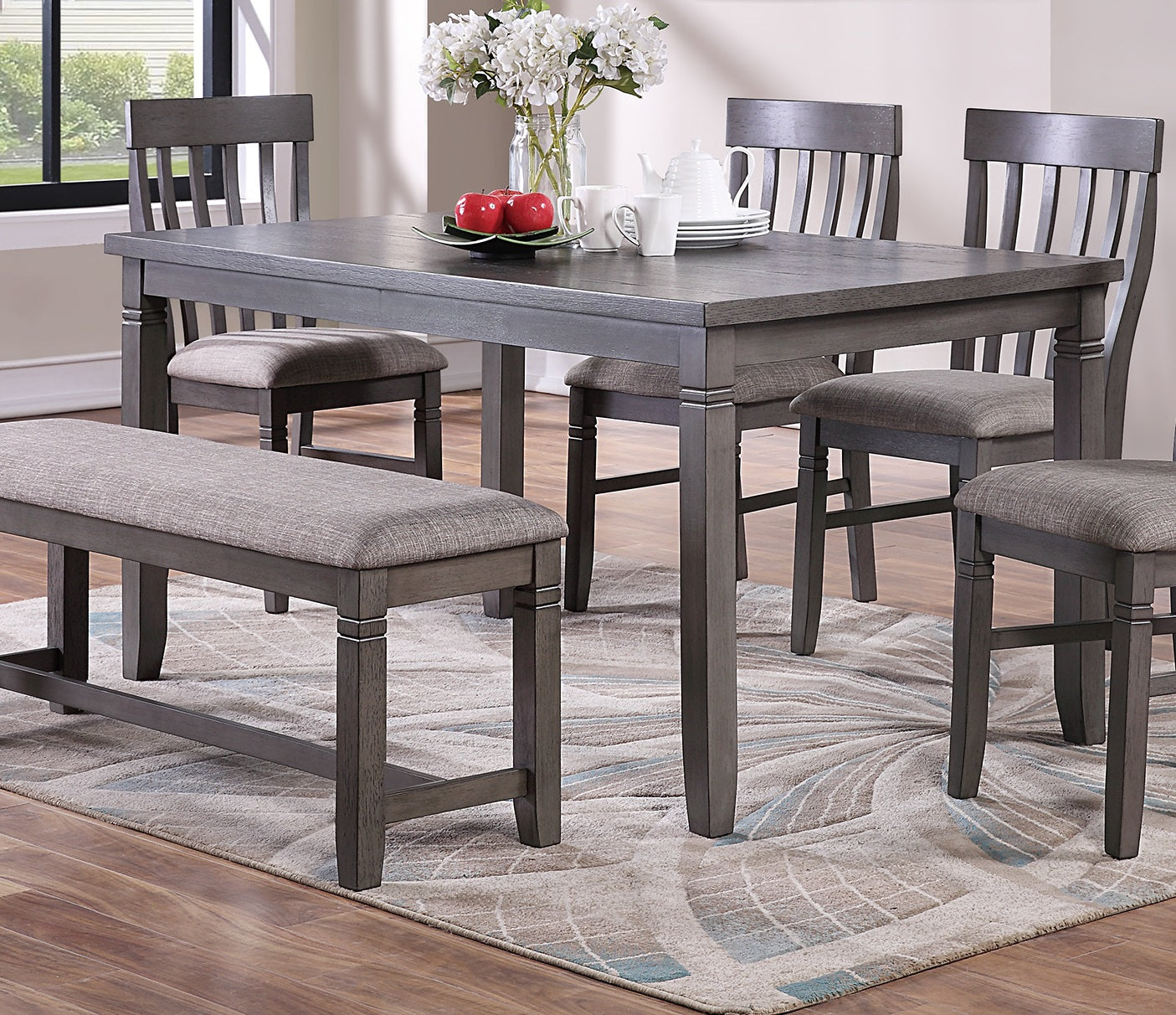 Gray wood dining table with upholstered bench seating and chairs
