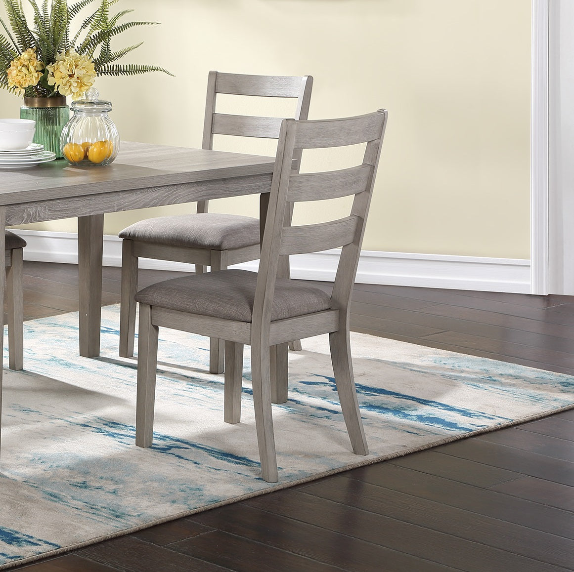 Gray wooden dining chairs with upholstered seats in a dining room