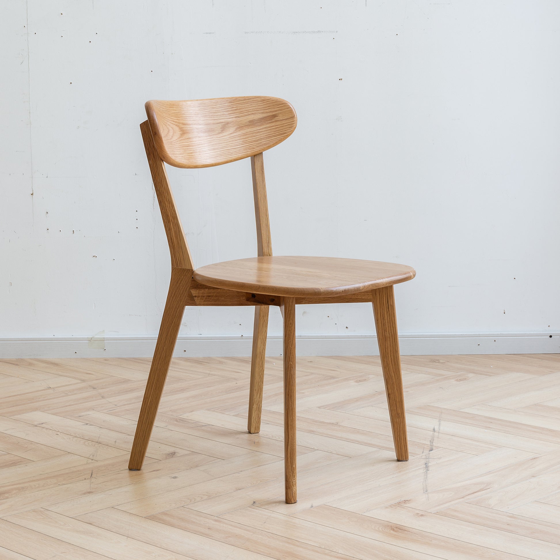 Light oak dining chair with curved backrest and natural wood grain