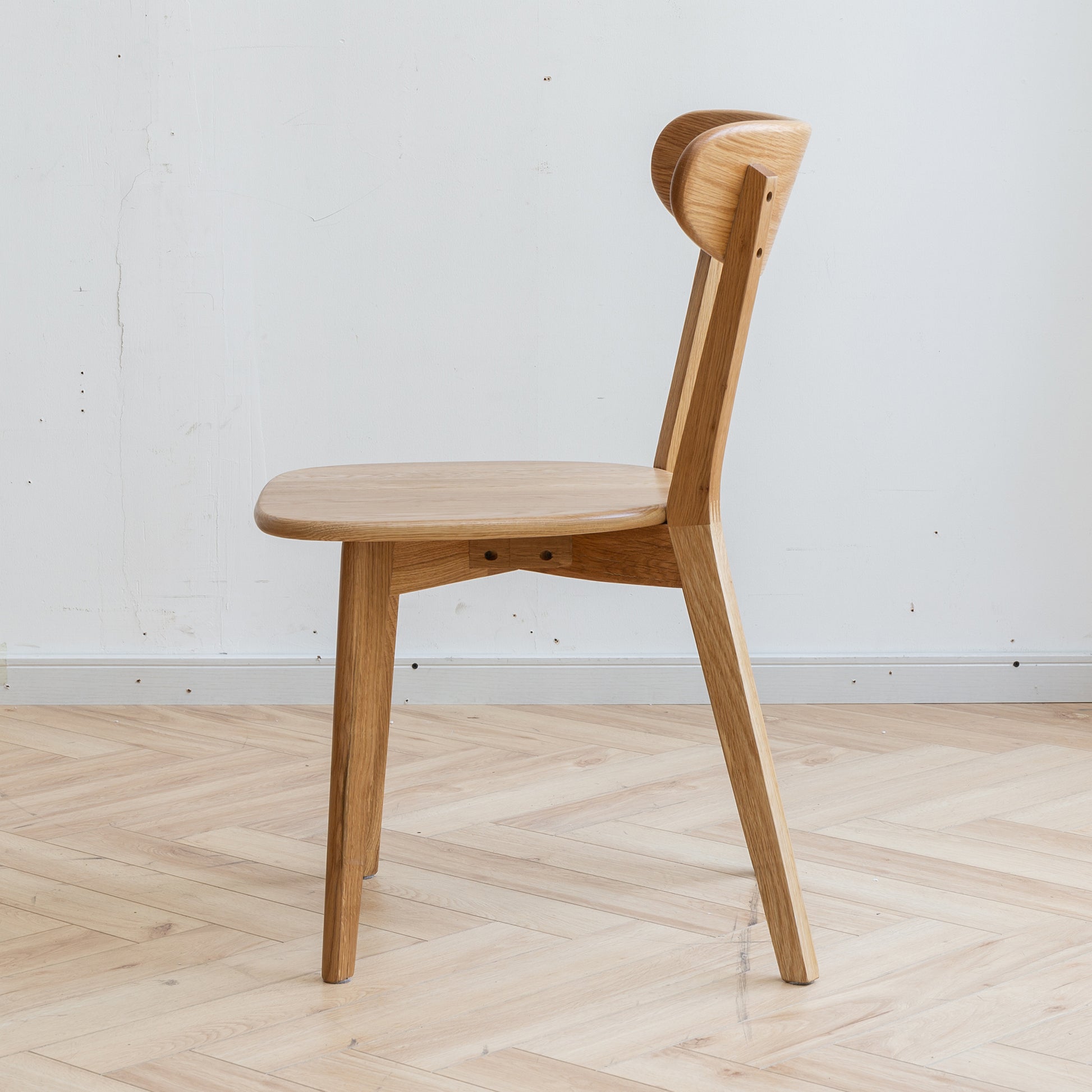 Minimalist oak dining chair with curved back