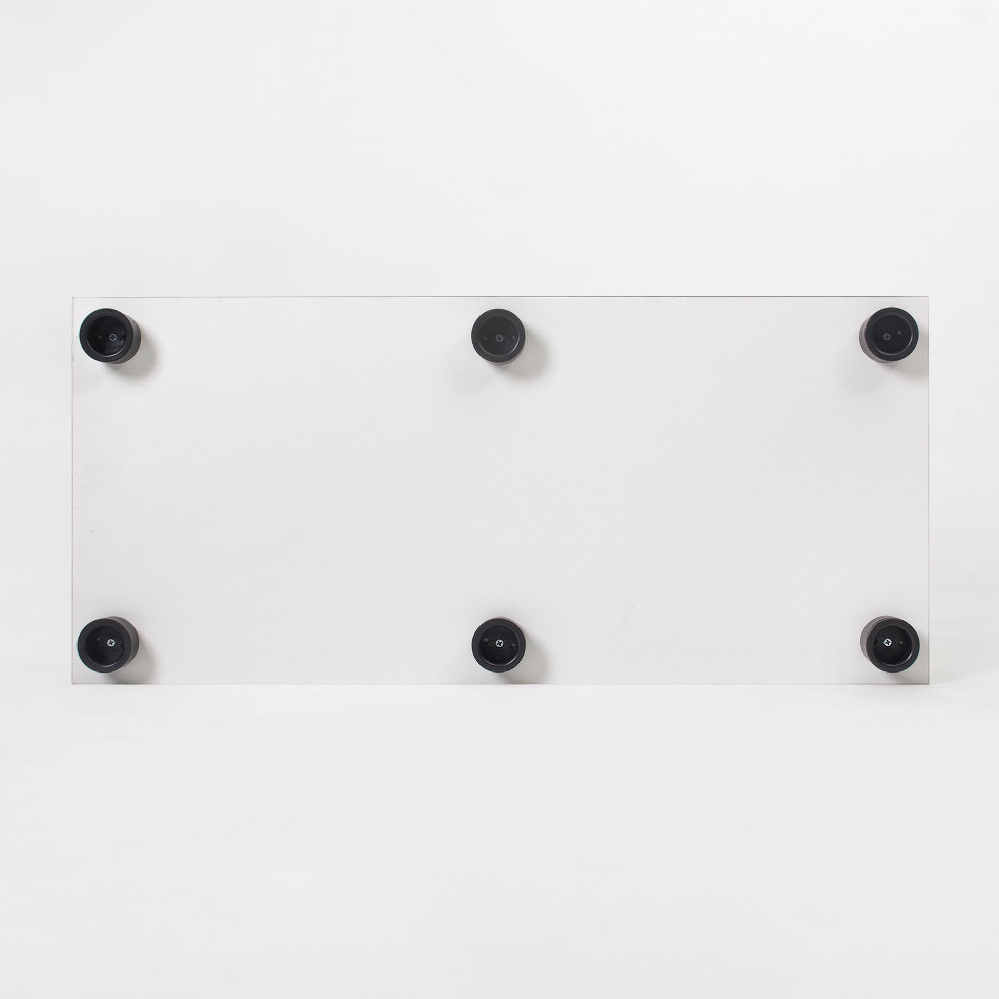 White rectangular shelf with six black rubber feet for stability