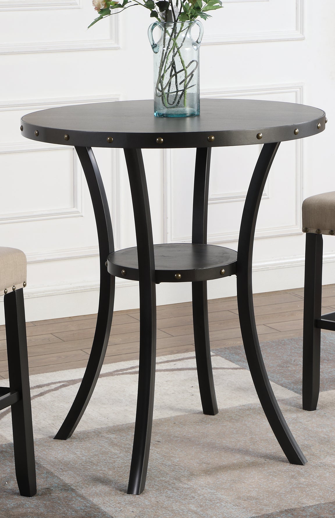 Round black industrial bar table with metal studs and curved legs