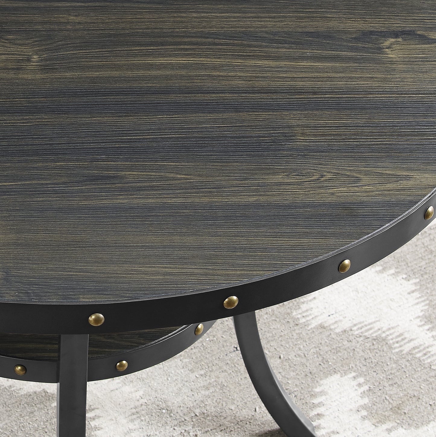 Round distressed wood coffee table with black metal trim and brass rivets