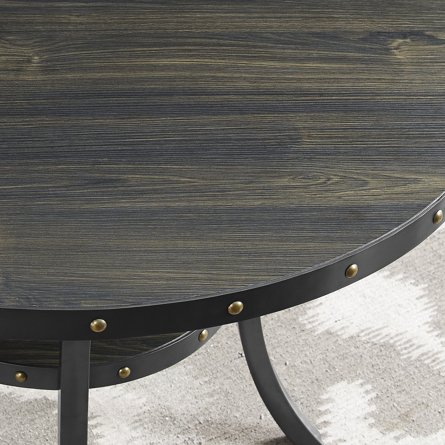 Round distressed wood coffee table with black metal trim and brass rivets