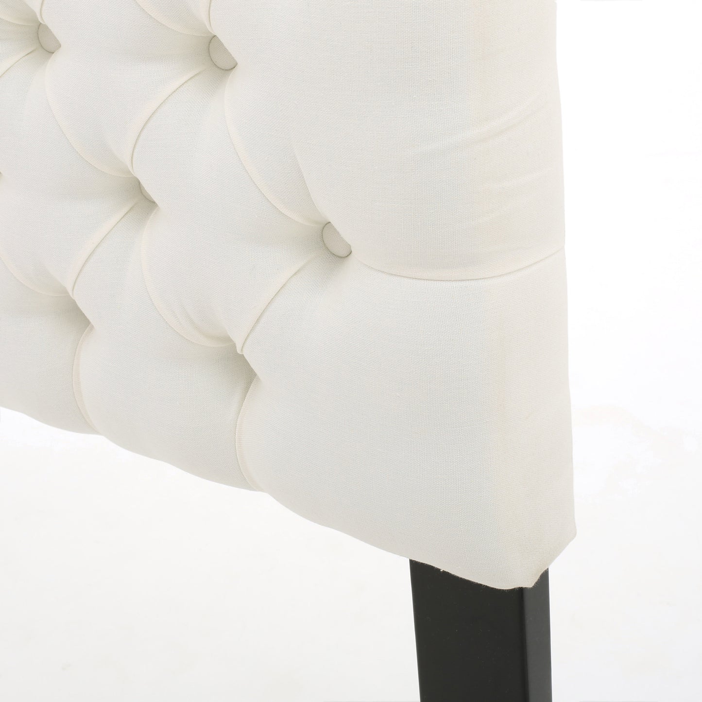 Cream tufted linen headboard detail with button tufting