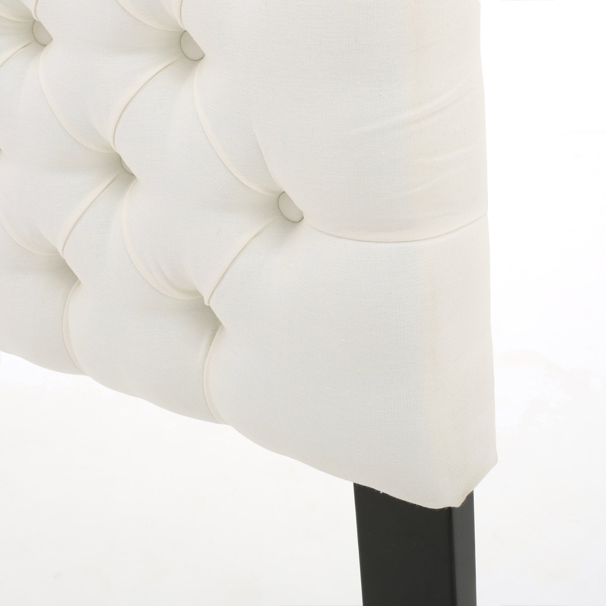 Cream tufted linen headboard detail with button tufting