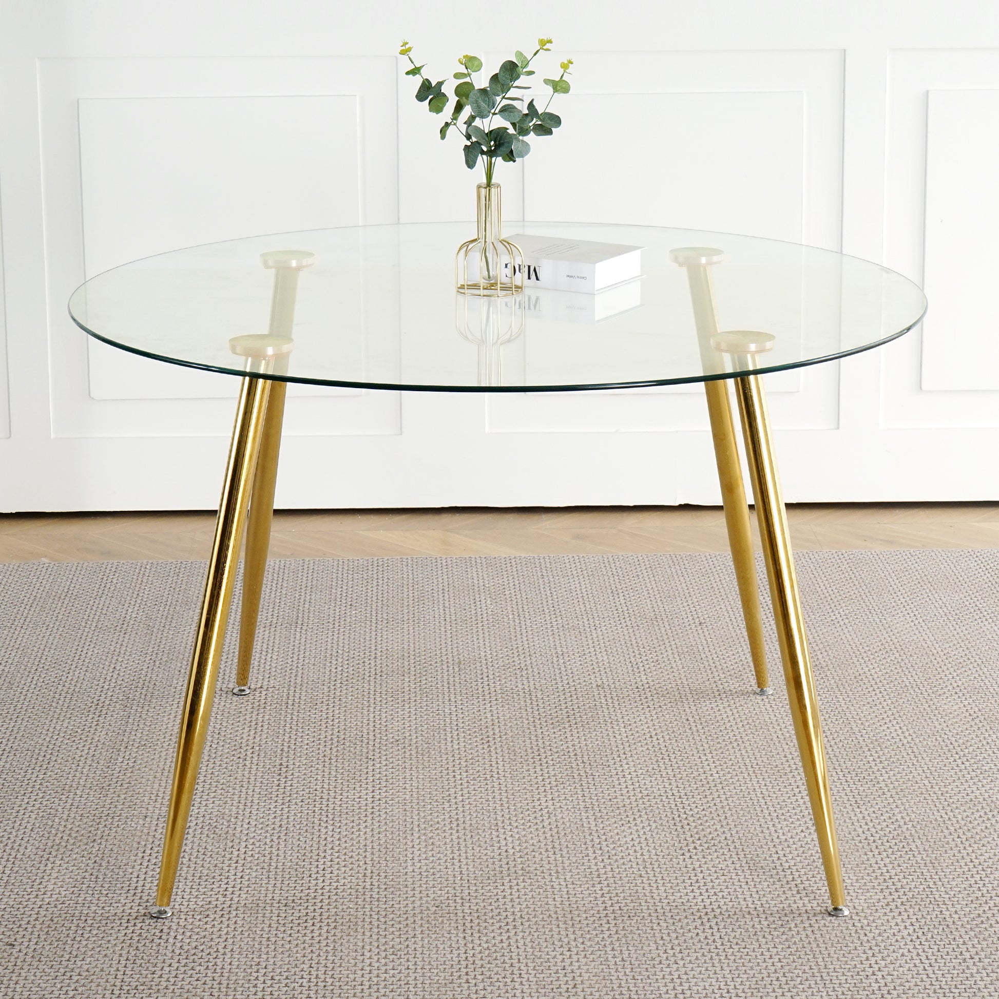 Round glass dining table with polished gold metal legs