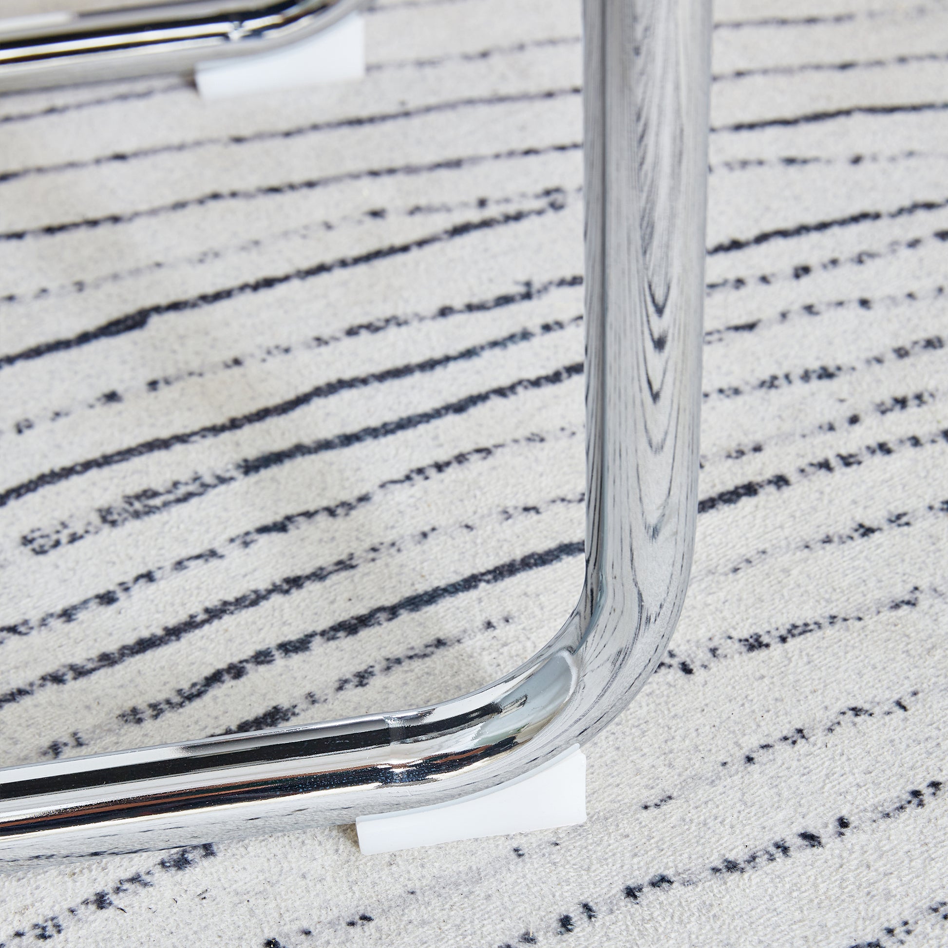 Chrome curved leg detail on textured rug