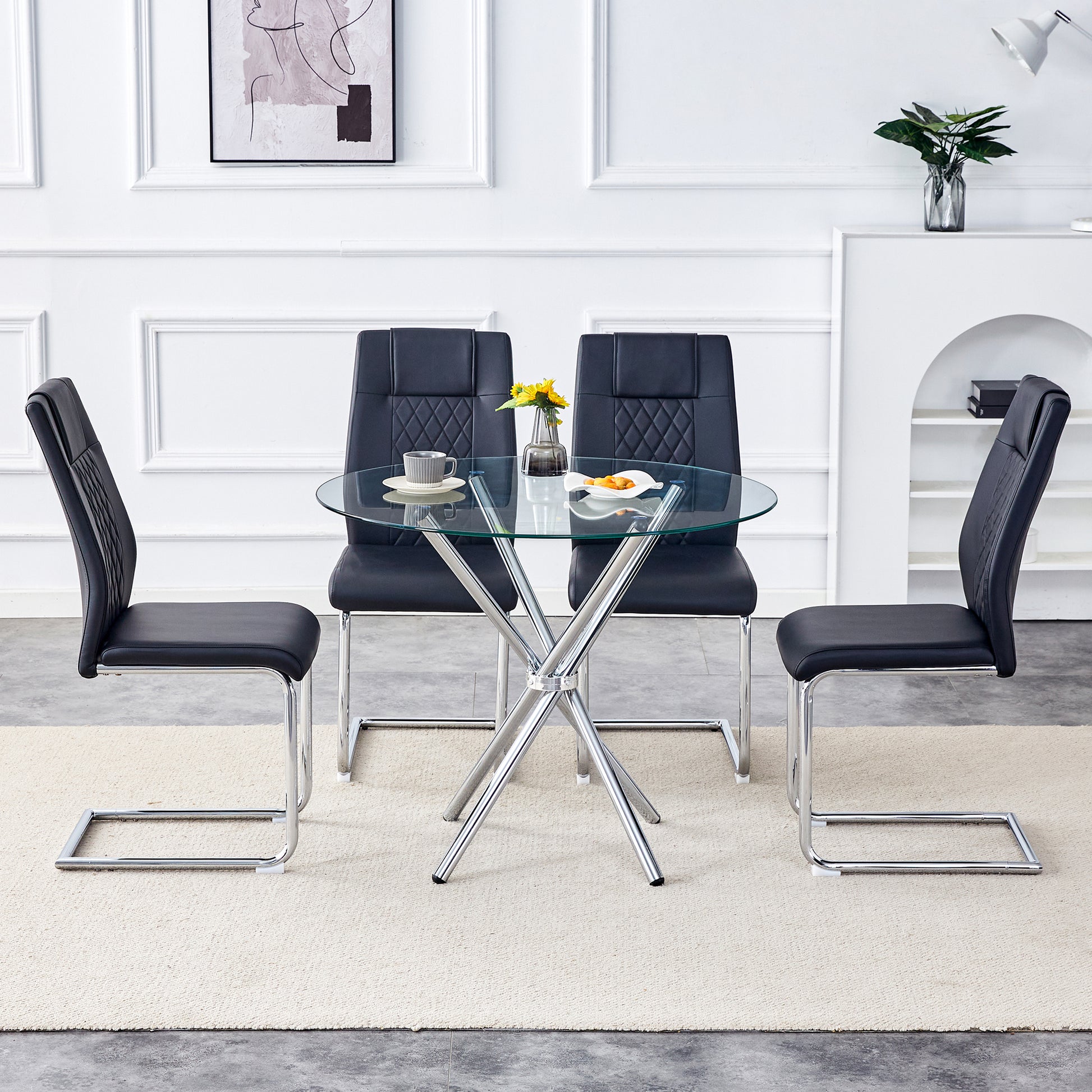 Round glass dining table with four black faux leather chairs