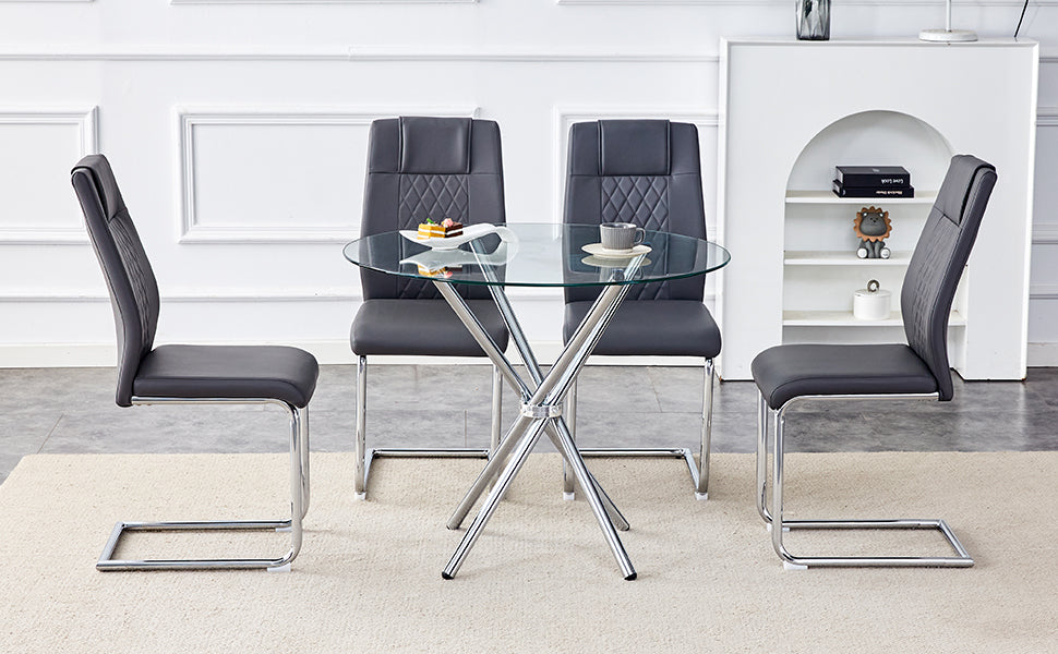 Modern dining set with four grey upholstered chairs and a round glasstop table with chrome legs