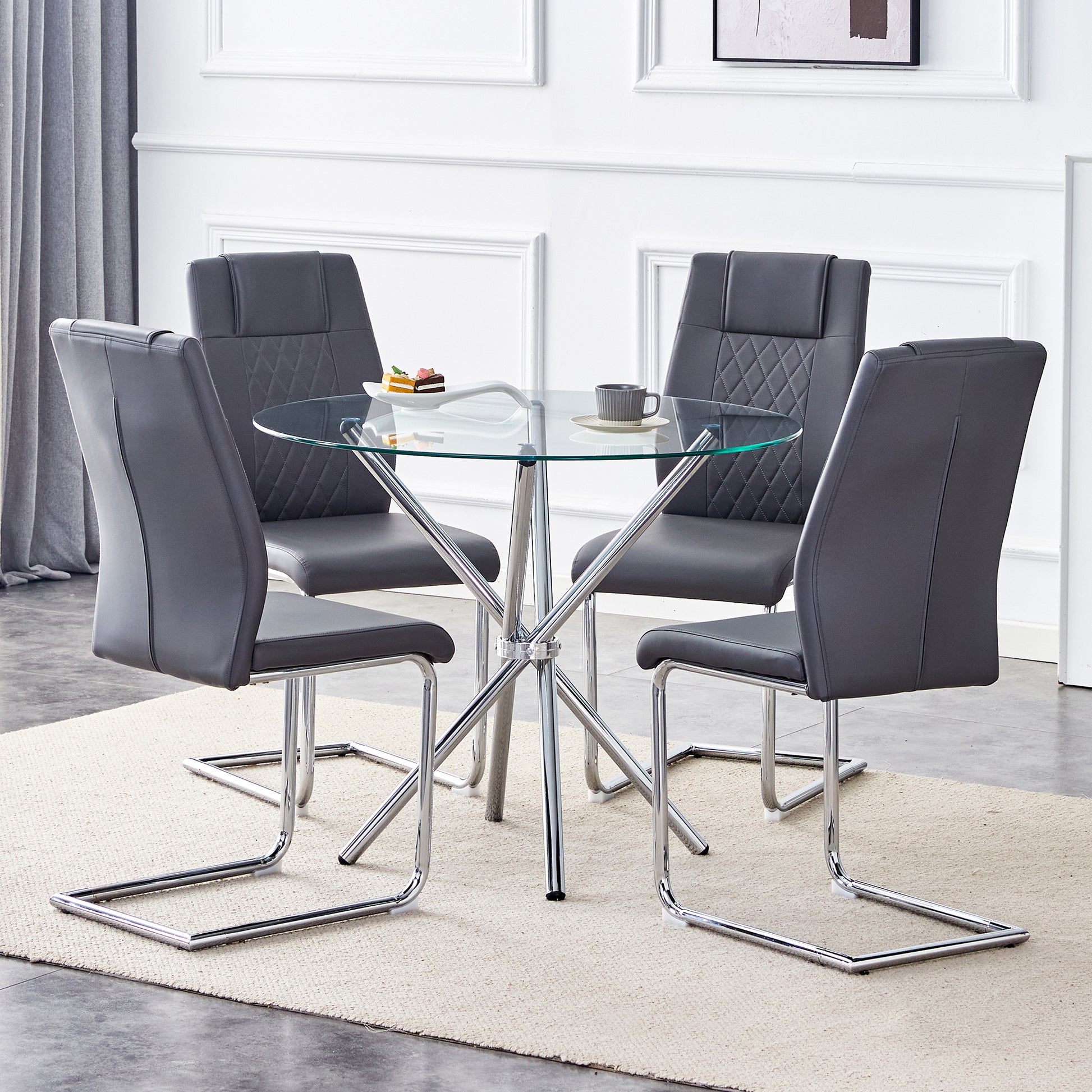 Round glass dining table with four gray faux leather chairs