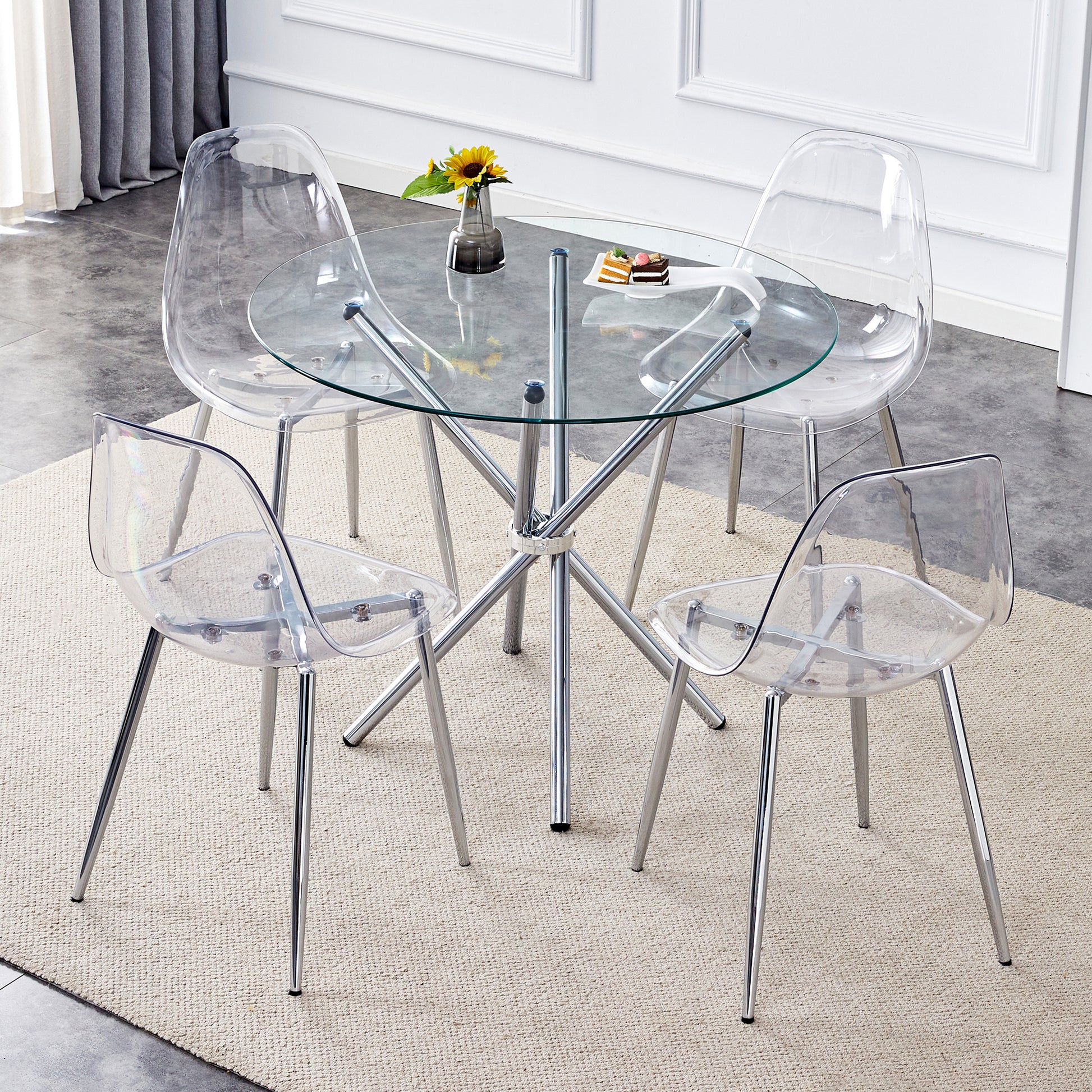 Clear acrylic dining chairs with chrome legs surrounding a glass top table