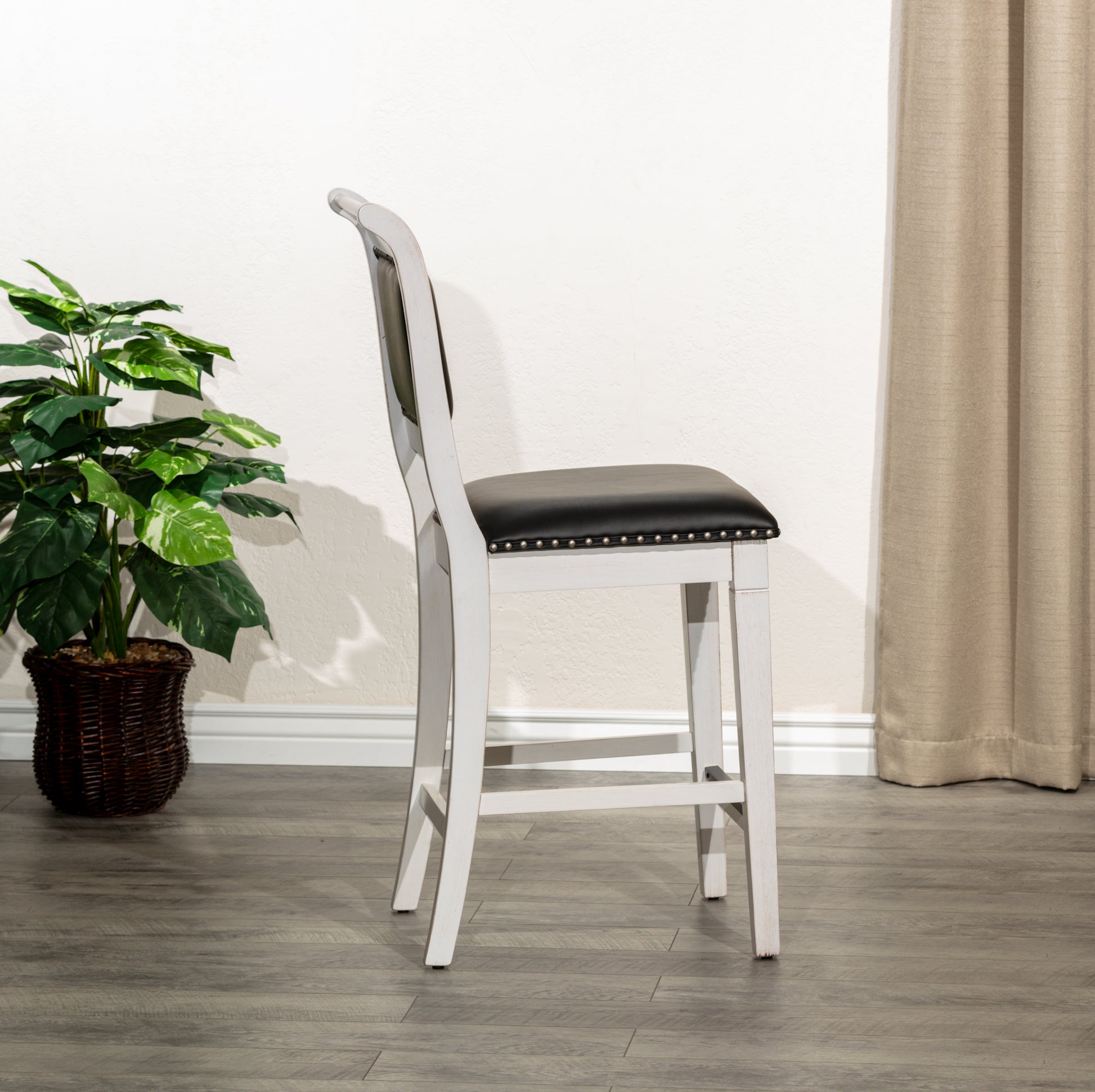 White wood counter stool with black upholstered seat and silver nailhead trim