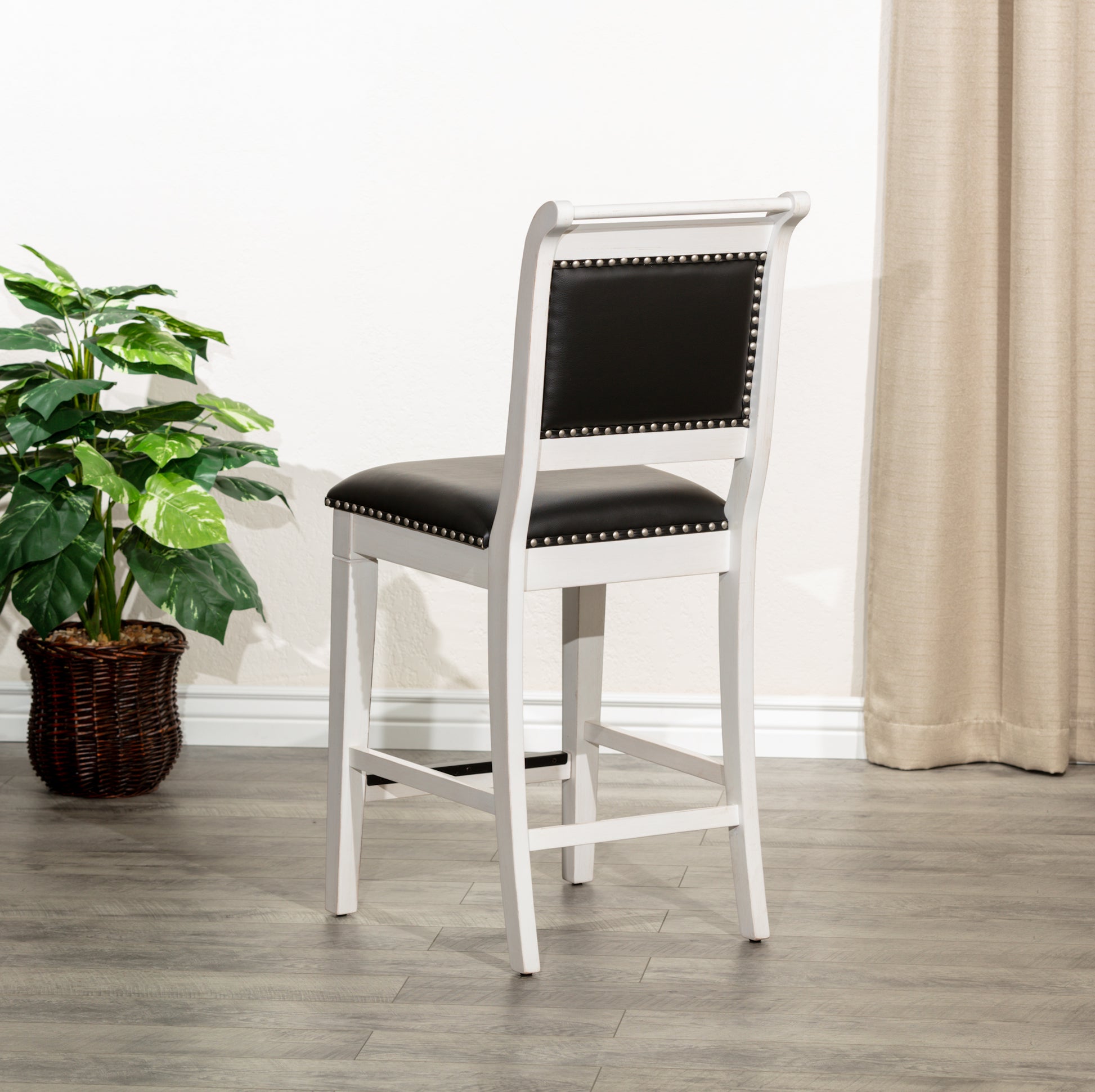 White upholstered bar stool with black faux leather seat and back studded detail