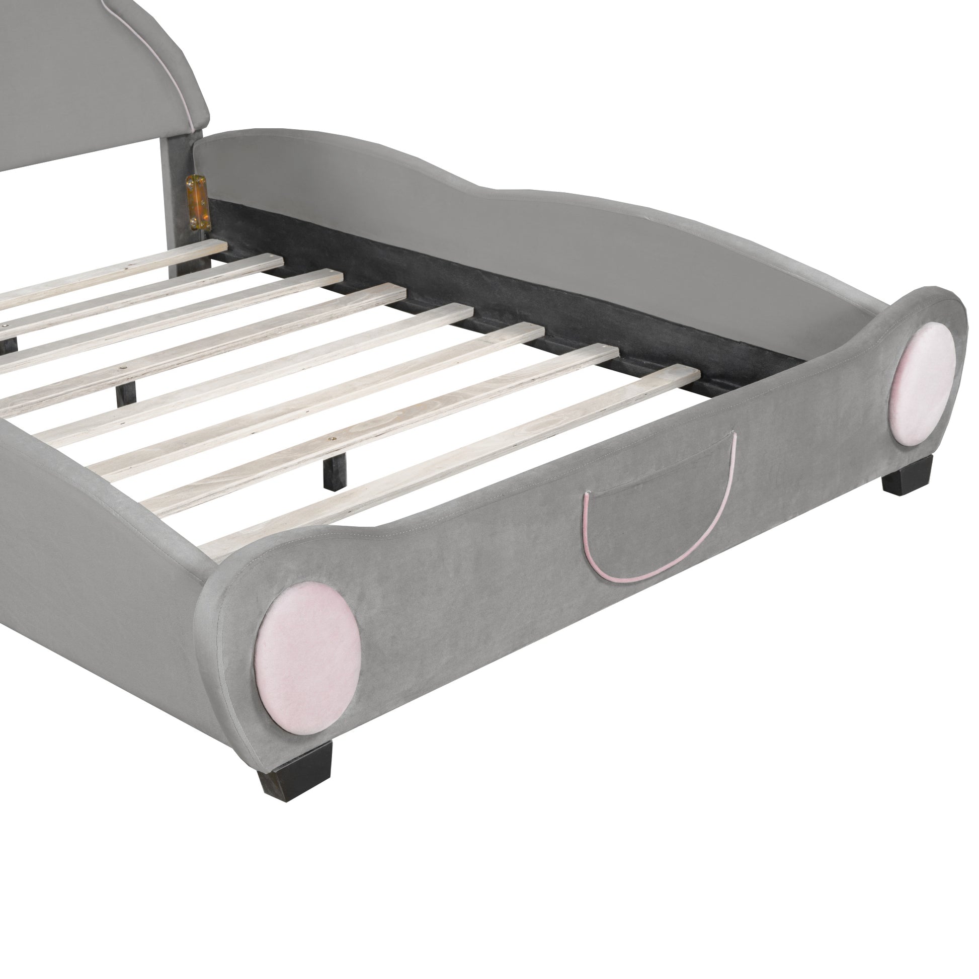 Gray velvet toddler bed with pink circular accents and wooden slats