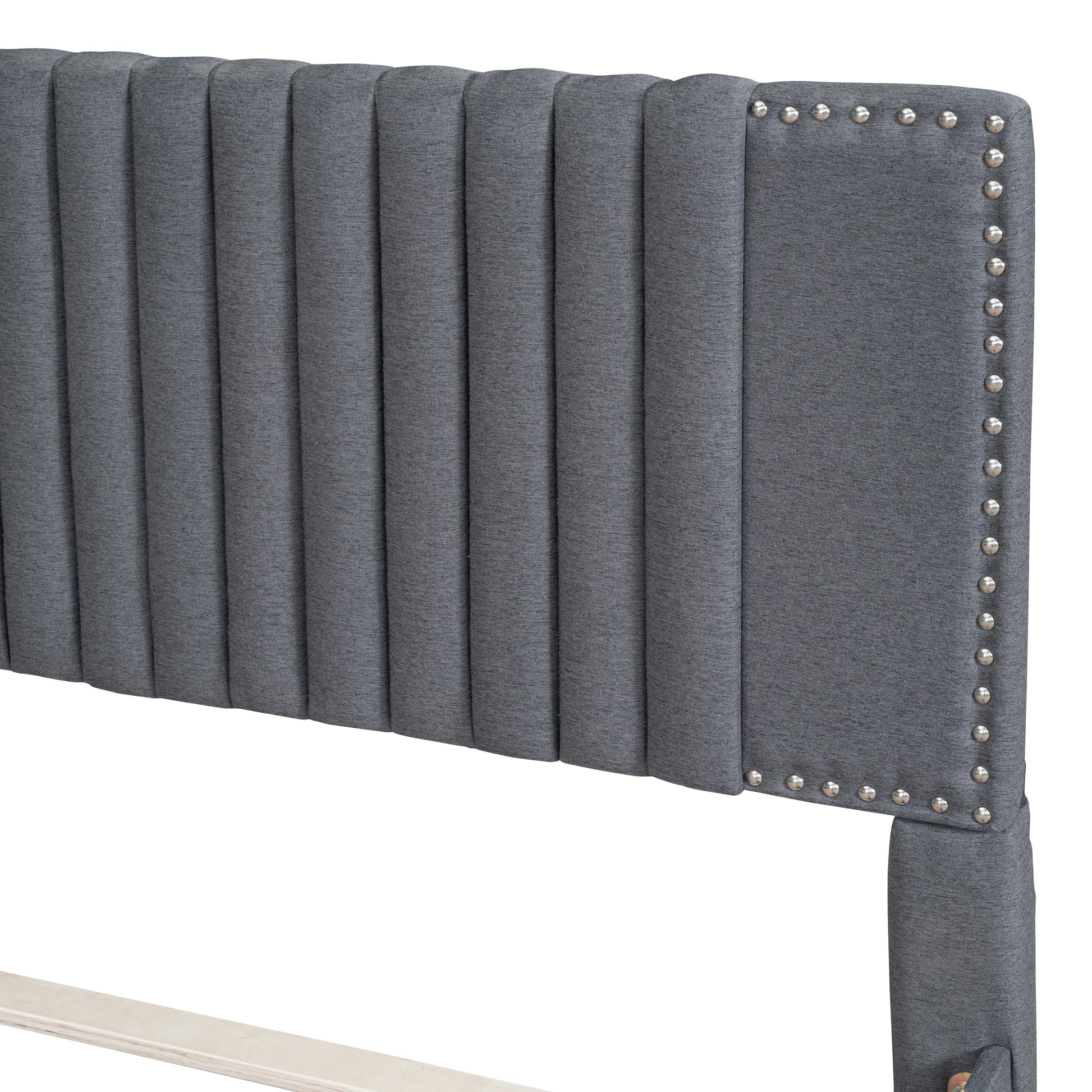 Grey upholstered headboard with vertical tufting and silver nailhead trim