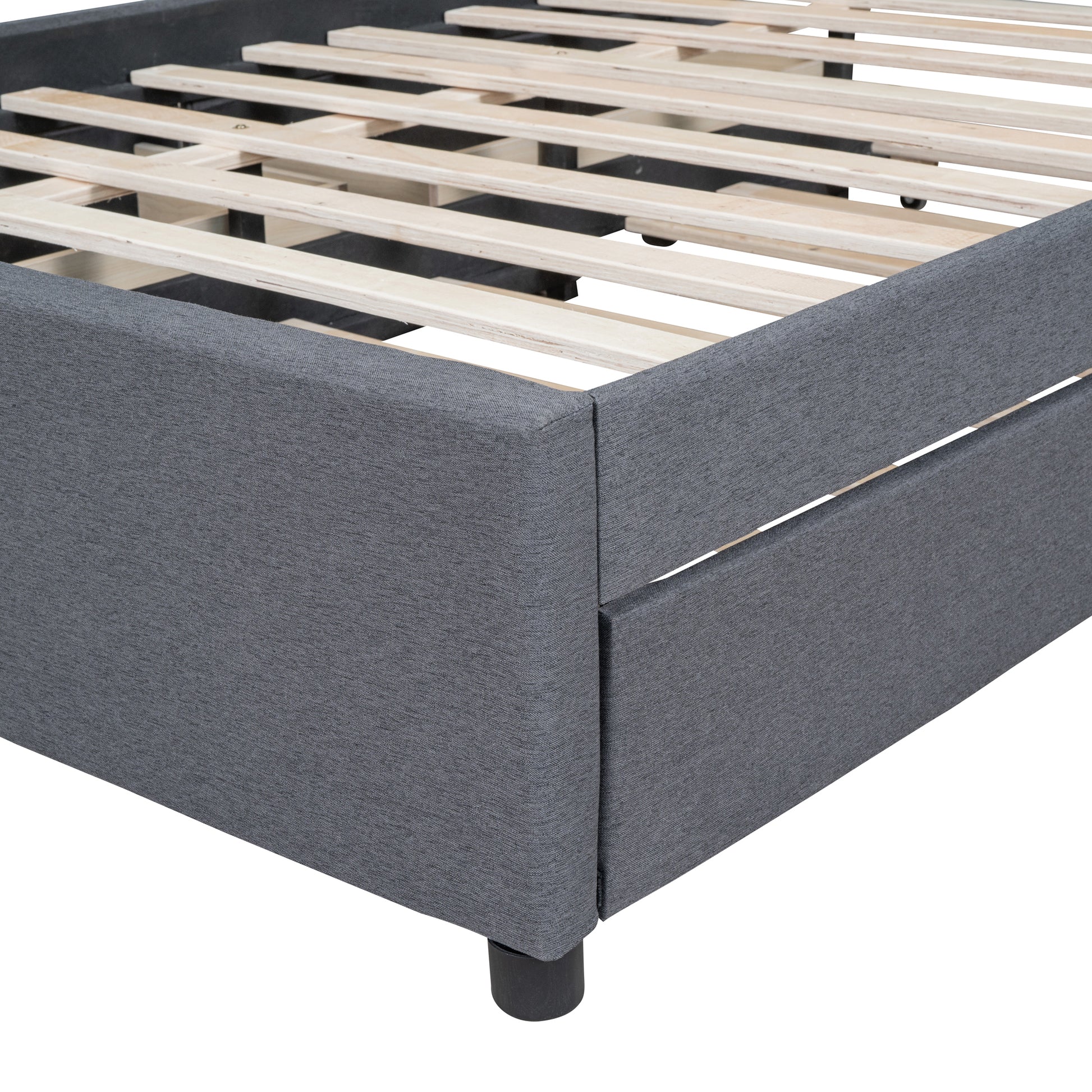 Closeup of grey upholstered bed frame with wooden slats