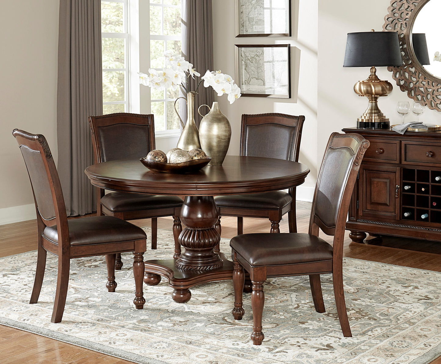 Round dark wood dining table with four brown leather chairs