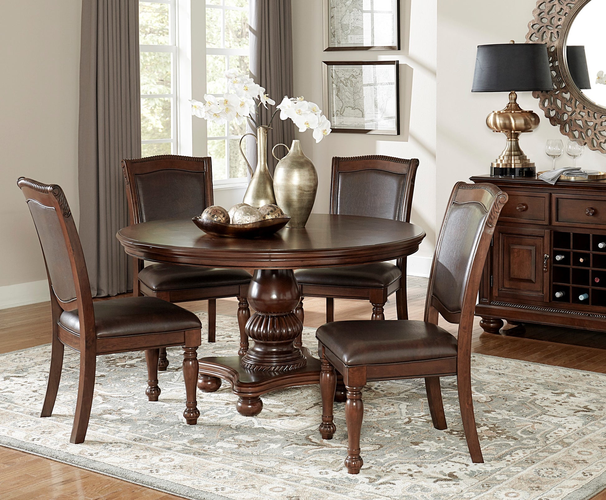 Round dark wood dining table with four brown leather chairs