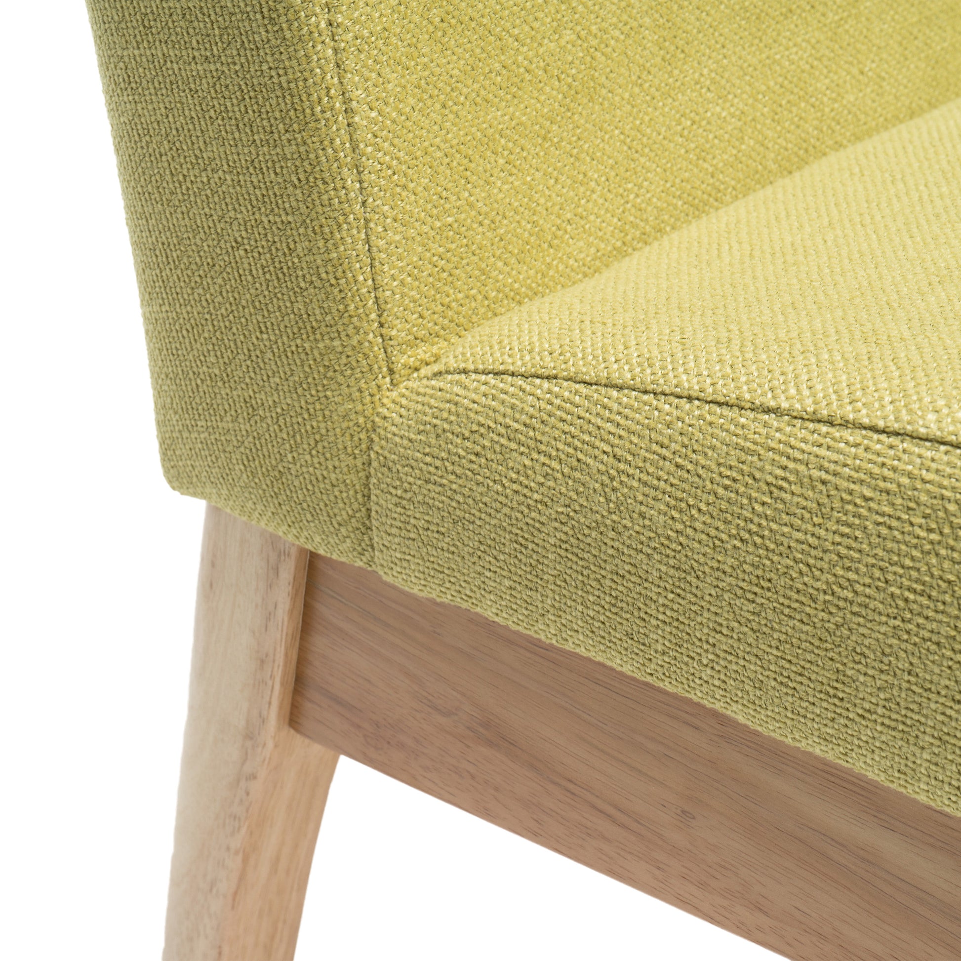 Closeup of a textured lime green fabric chair seat with light wood legs