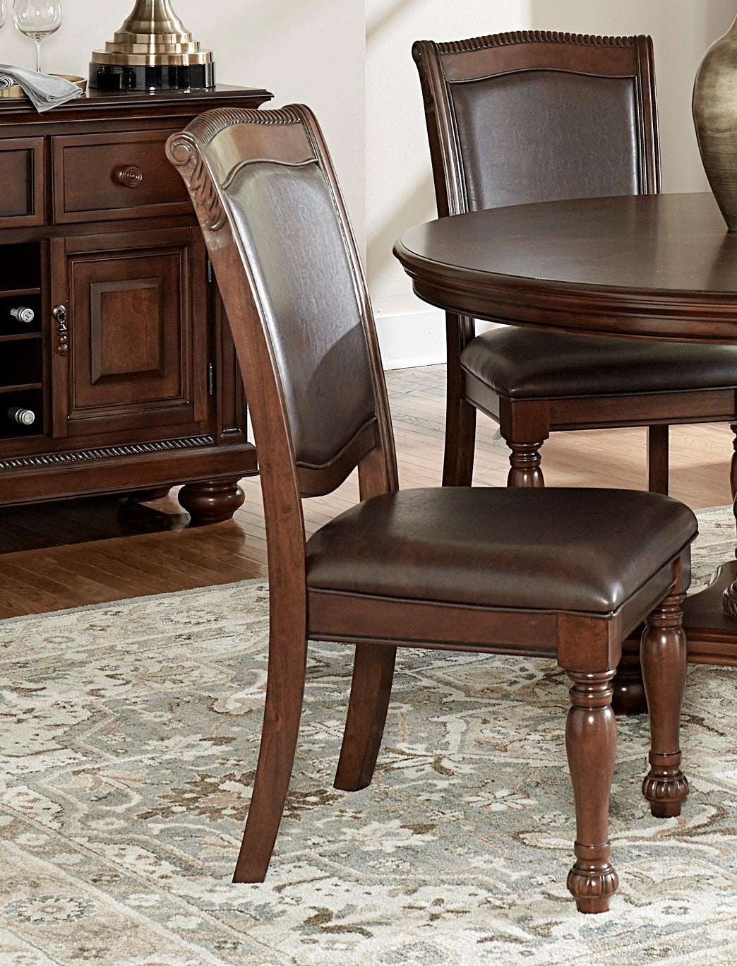 Brown leather upholstered dining chair with carved wooden frame