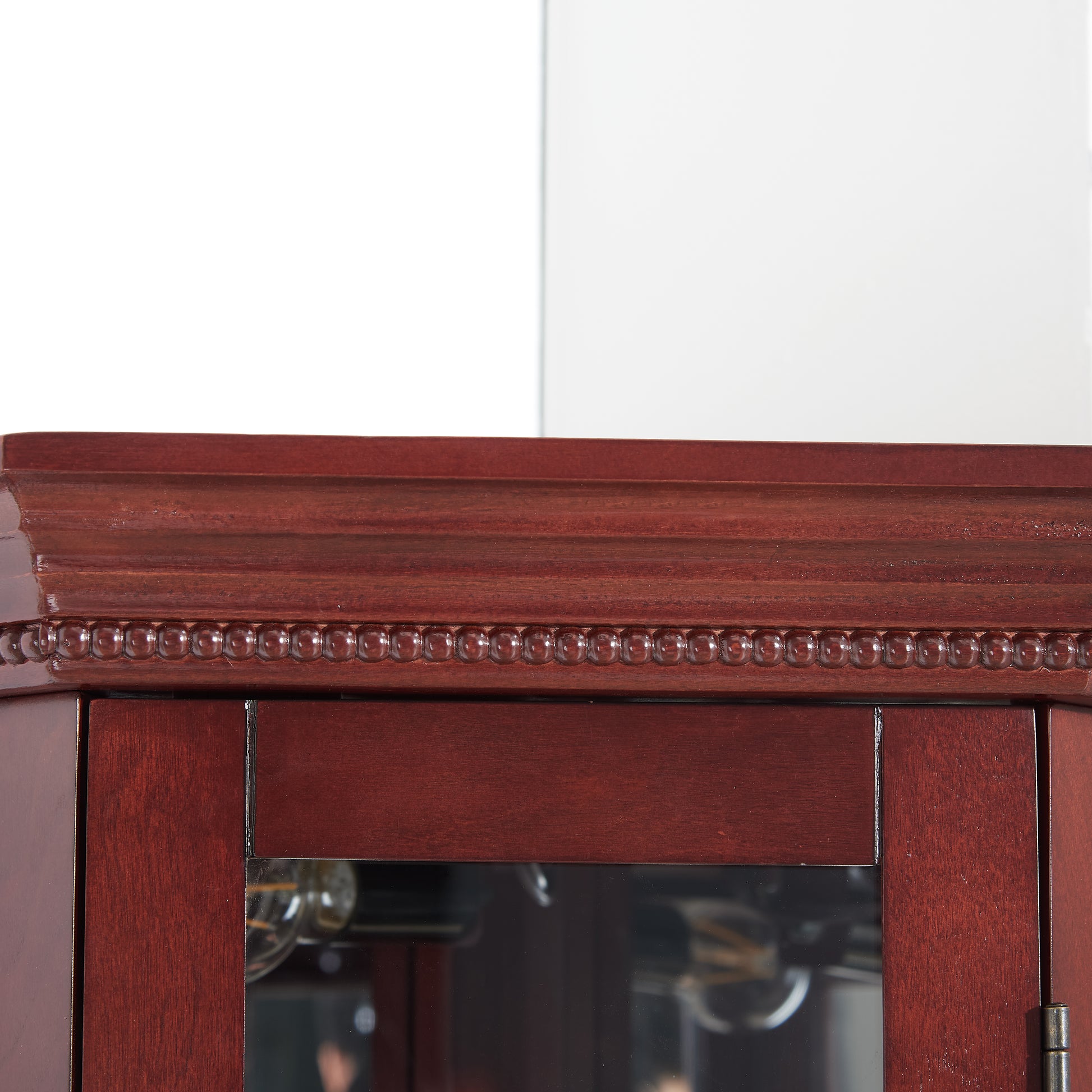 Mahogany corner cabinet top with beaded trim and glass door detail