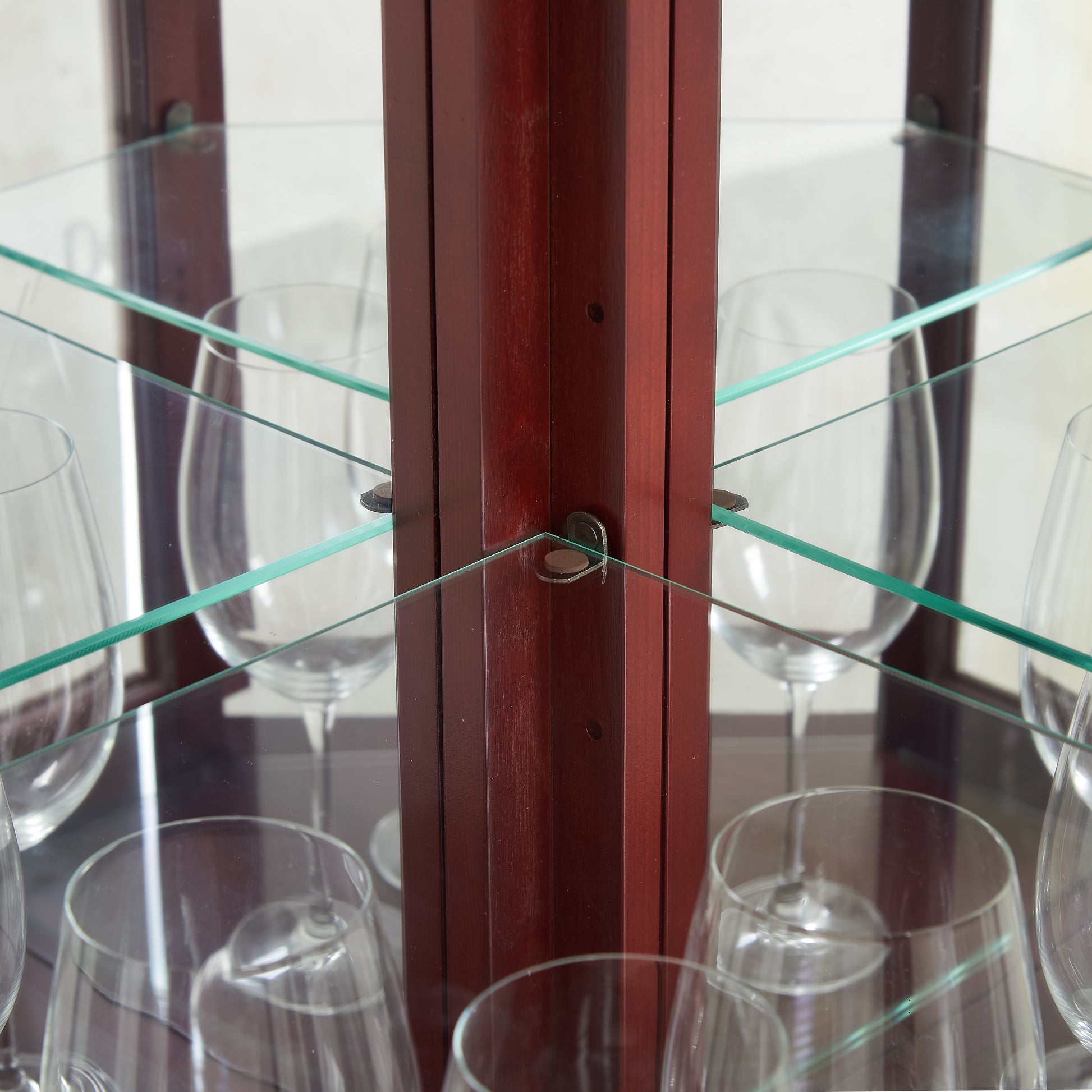 Mahogany corner curio cabinet with clear glass shelves and wine glasses