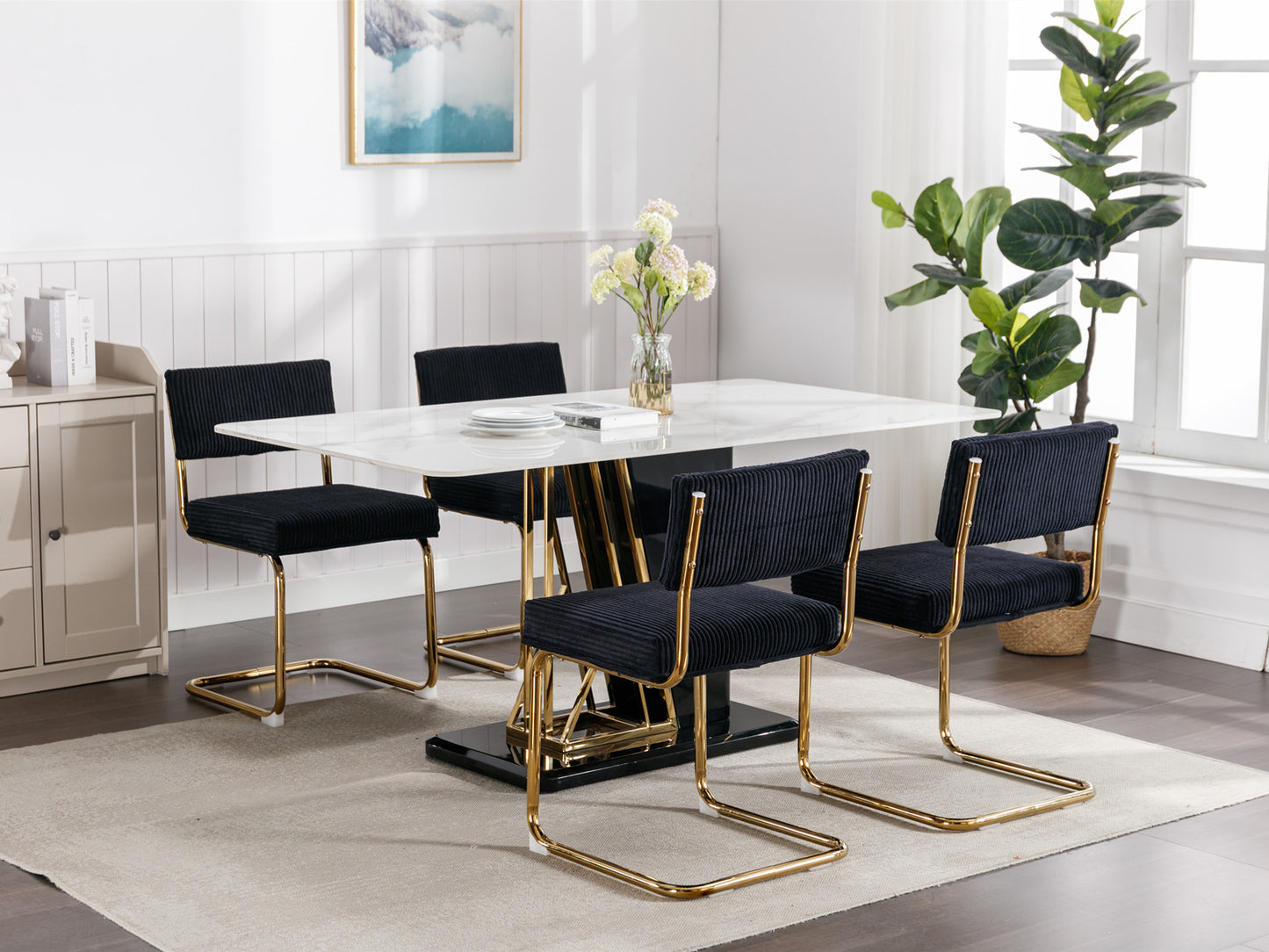 Black corduroy dining chairs with gold metal frames around a white table