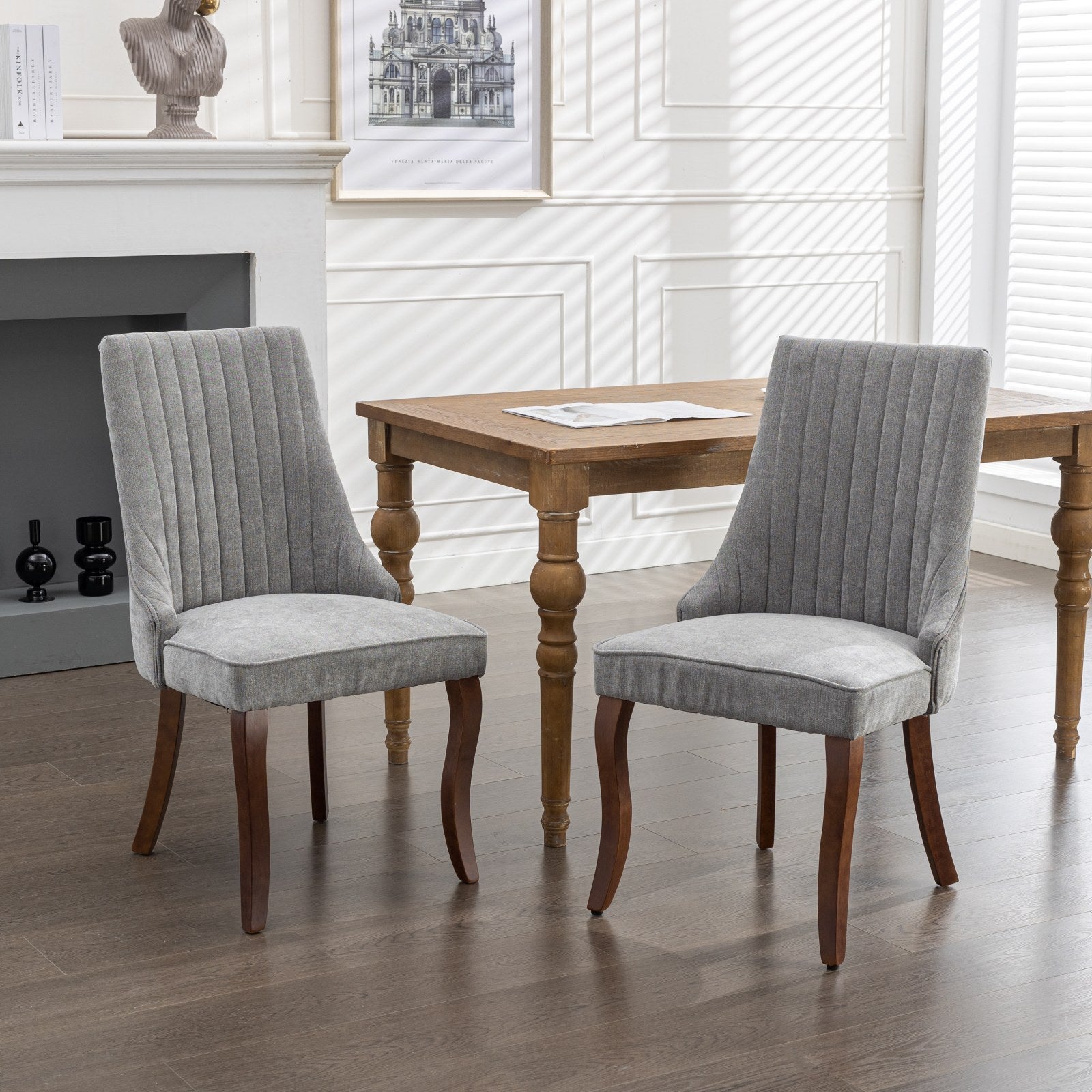 Grey upholstered dining chair with vertical tufting and dark wood legs