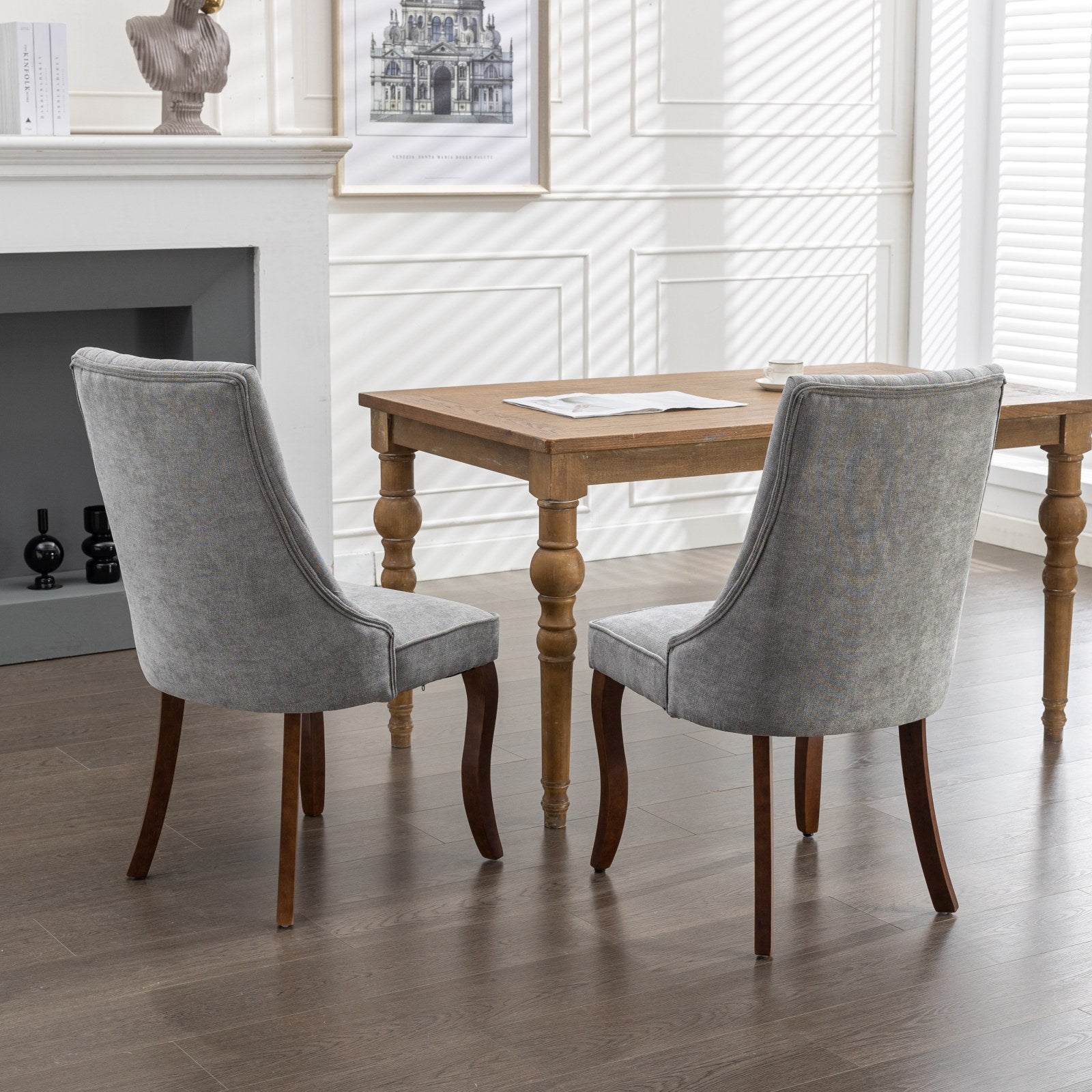 Gray upholstered dining chairs with curved wooden legs