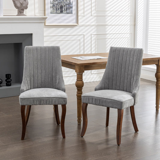 Pair of grey upholstered dining chairs with channel tufting and dark wood legs