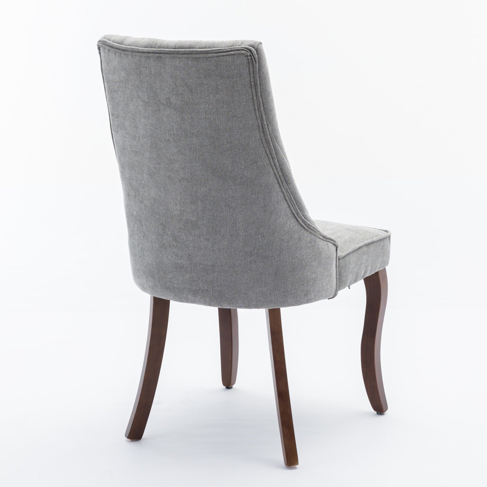 Grey upholstered dining chair with tufted back and dark wood legs