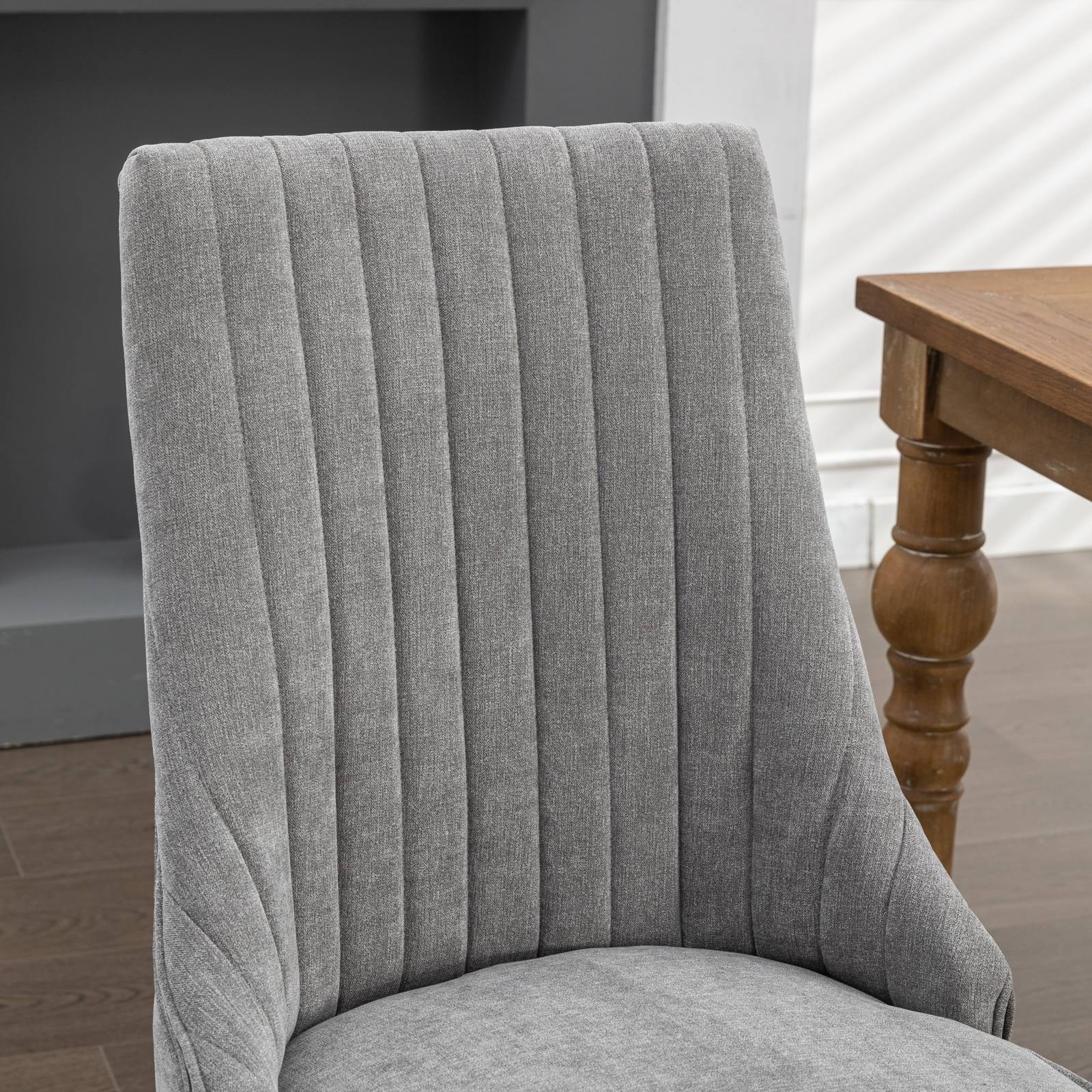 Gray fabric dining chair with vertical channel tufting and curved back