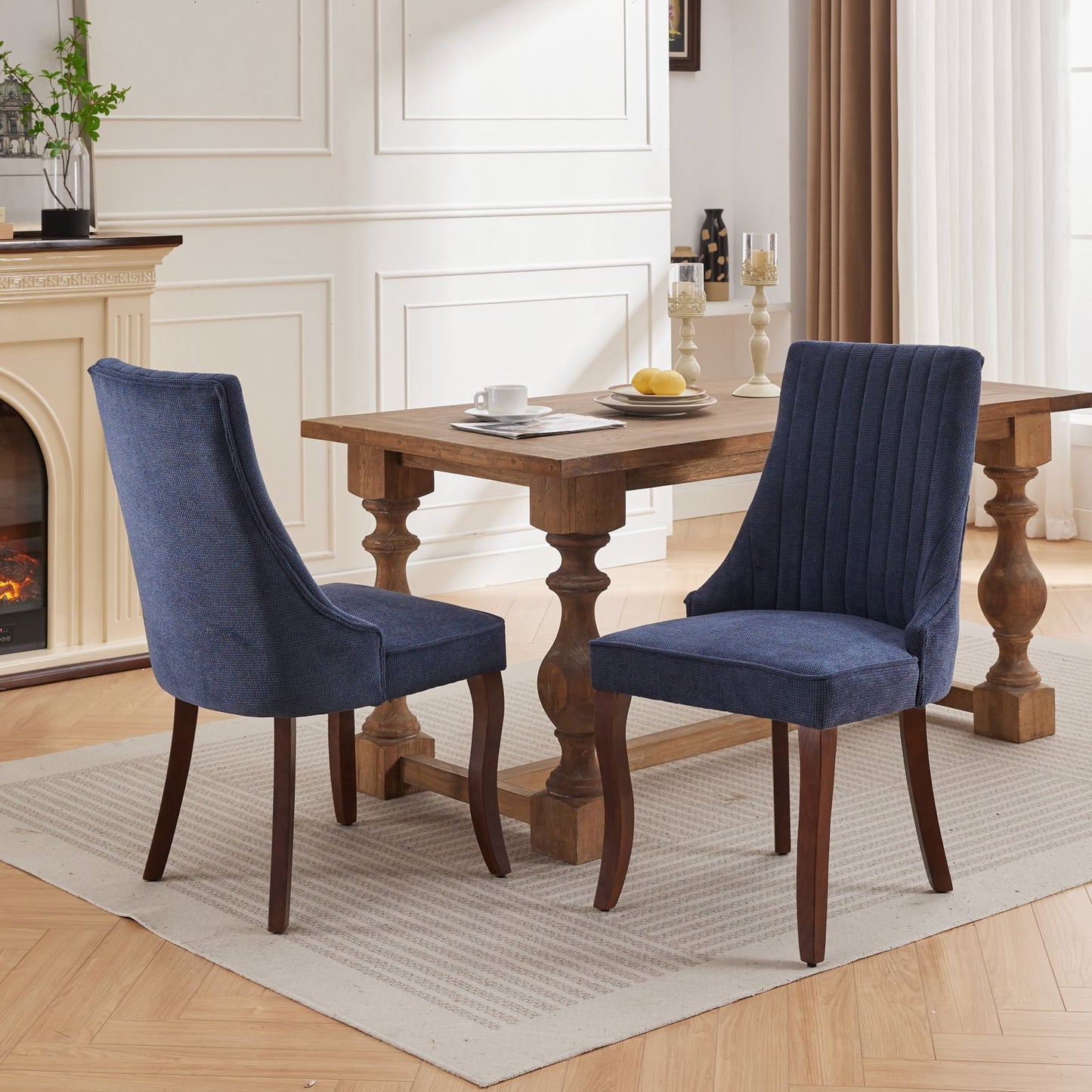 Two navy blue upholstered dining chairs with ribbed backs flank a rustic wooden dining table