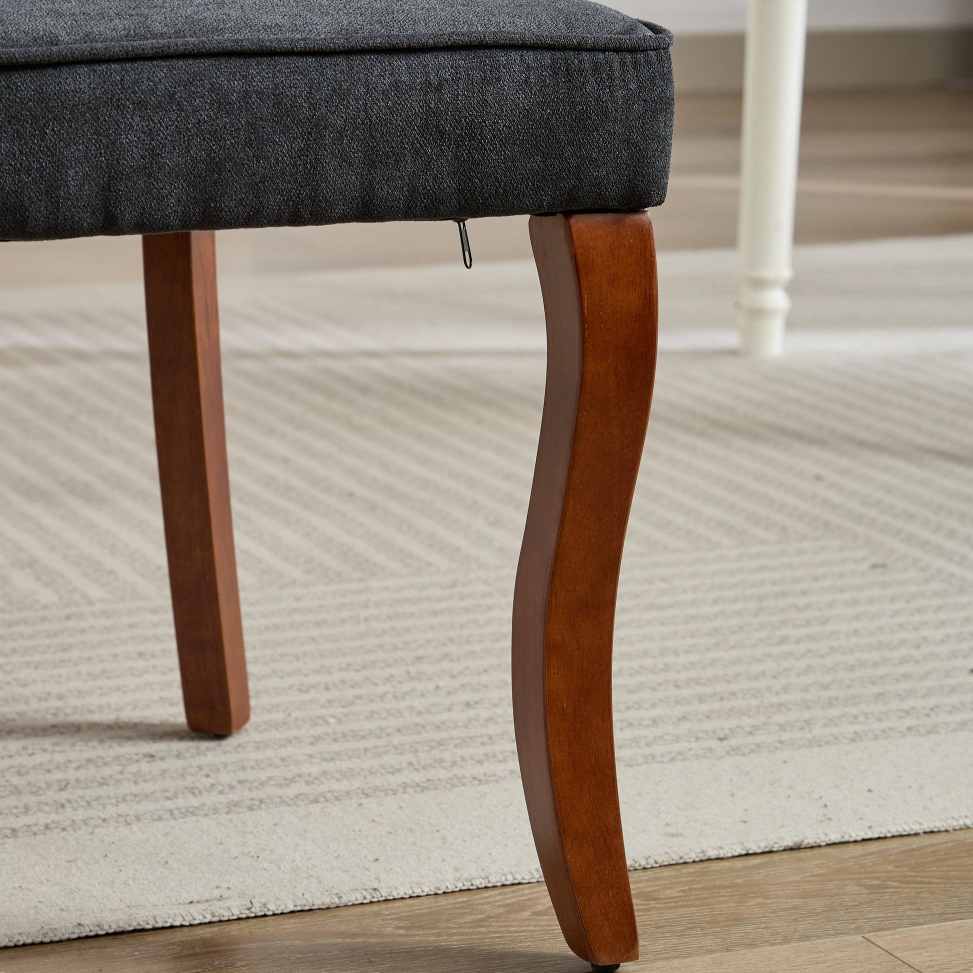 Dark gray upholstered chair with curved wooden legs