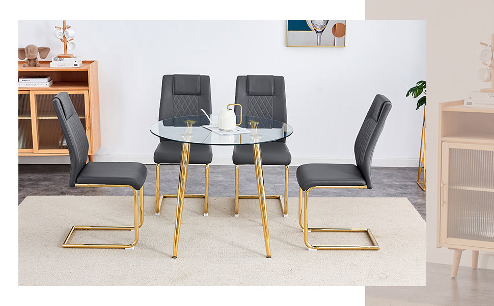 Round glass top dining table with gold legs and four grey upholstered chairs
