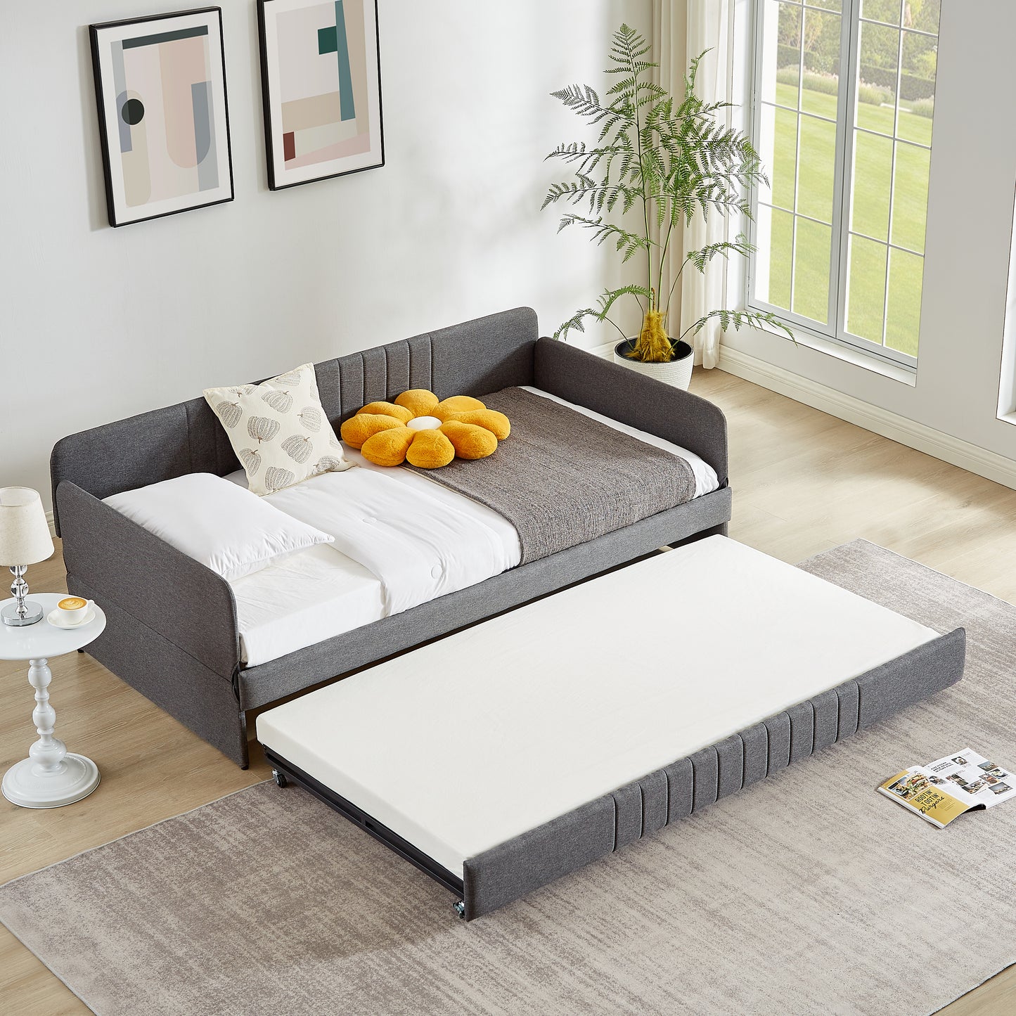 Modern grey upholstered daybed with a pullout trundle bed for dual functionality