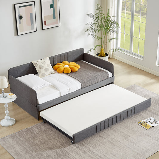 Modern grey upholstered daybed with a pullout trundle bed for dual functionality