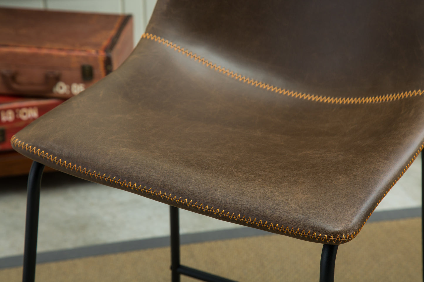 Brown faux leather bar stool seat with orange stitching