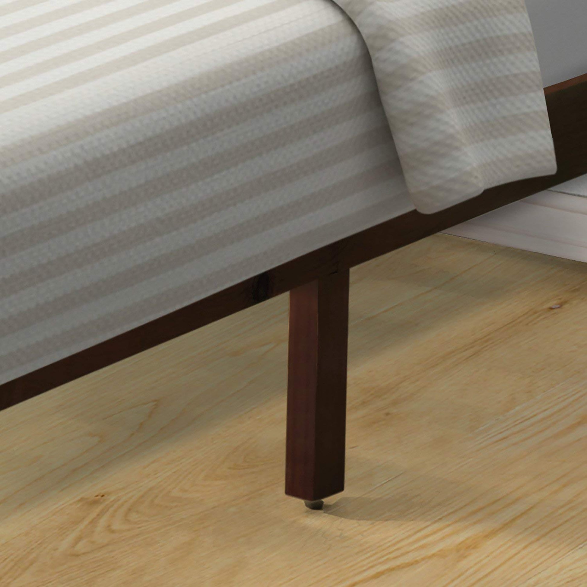 Dark brown wooden bed frame leg with white pinstripe duvet cover