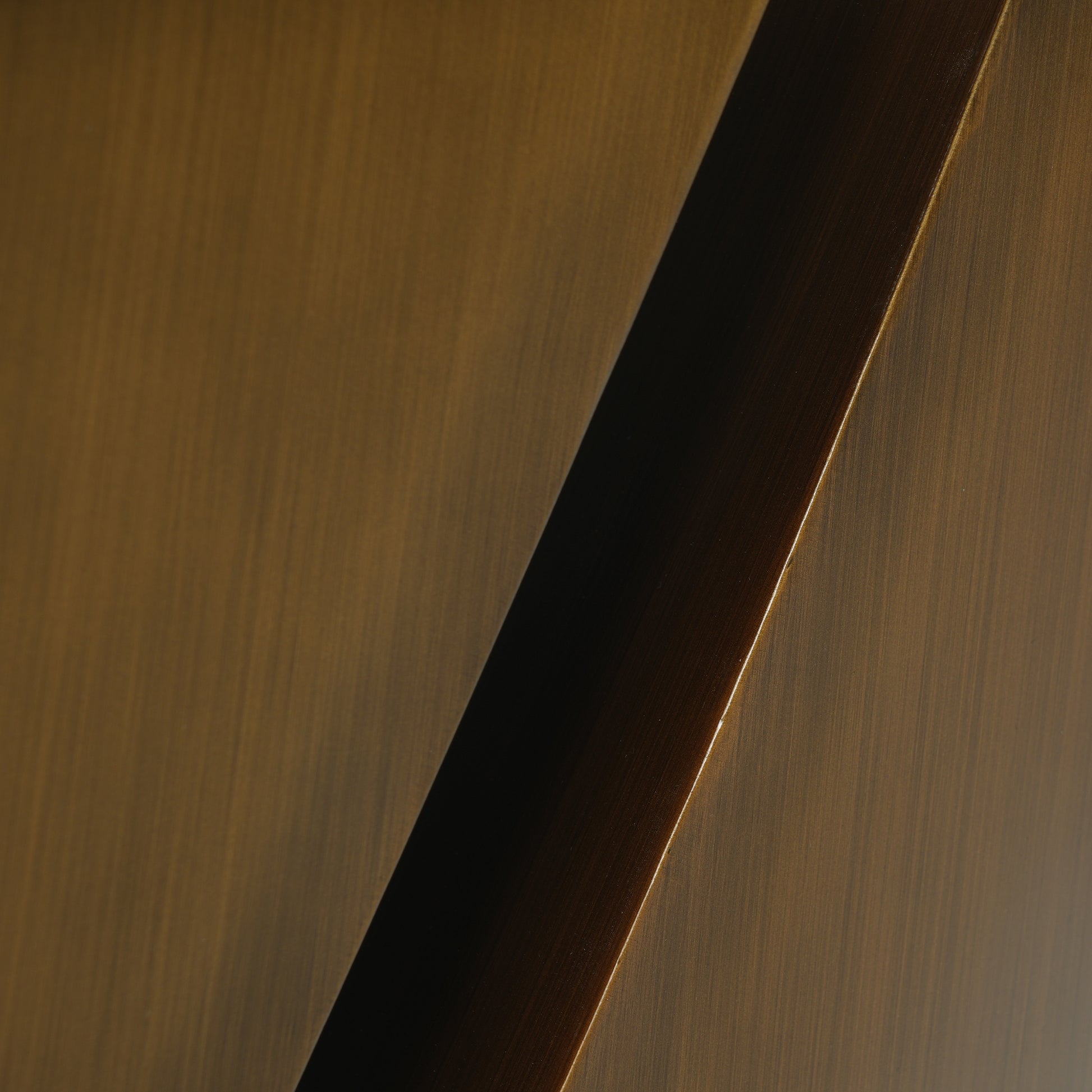 Brushed bronze metal surface with diagonal dark accent stripe