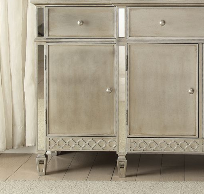 Mirrored silver cabinet with decorative patterned base and metallic knobs
