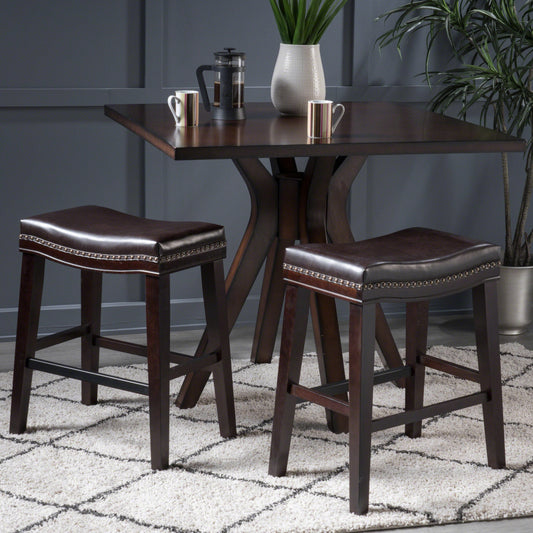 Dark brown faux leather bar stool with nailhead trim and dark wood legs