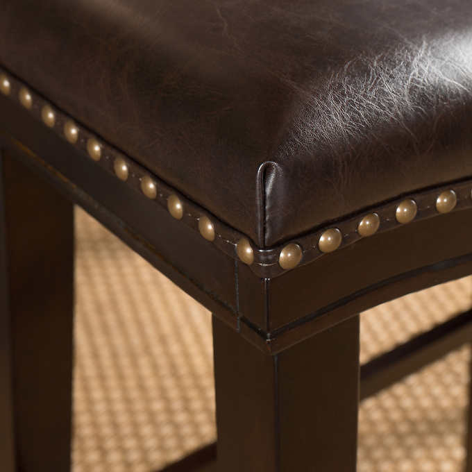 Dark brown faux leather counter stool with brass nailhead trim